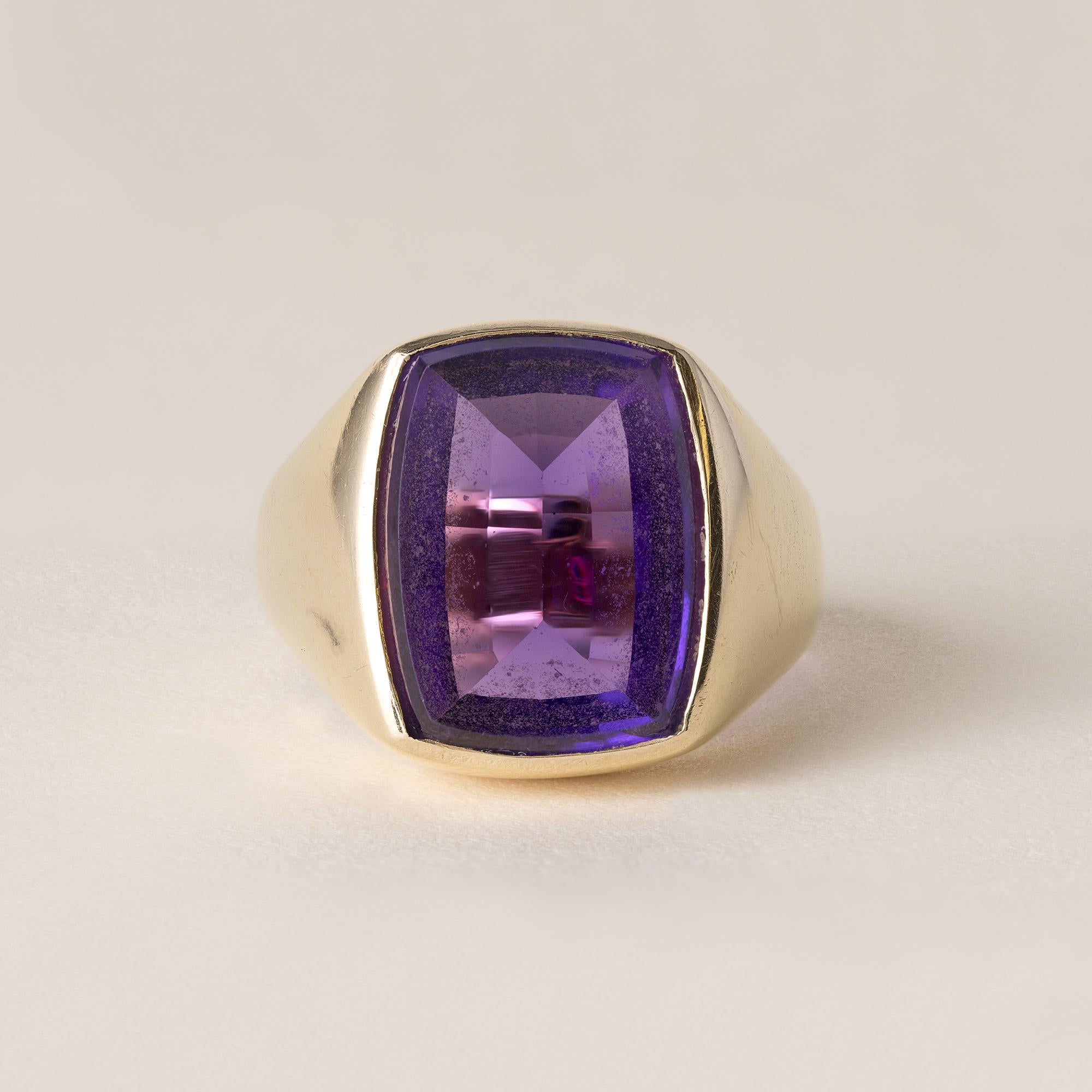Circa 1950s
Amethyst rectangular cushion measures 15mm x 12.3mm
~8 carats
Fine clean and vivid purple
Flat portrait cut table with a faceted pavilion
Bezel set in 14k gold
11 grams
Ring size 9.75
Stamped 14K 585 M in shank
Band measures 15mm at