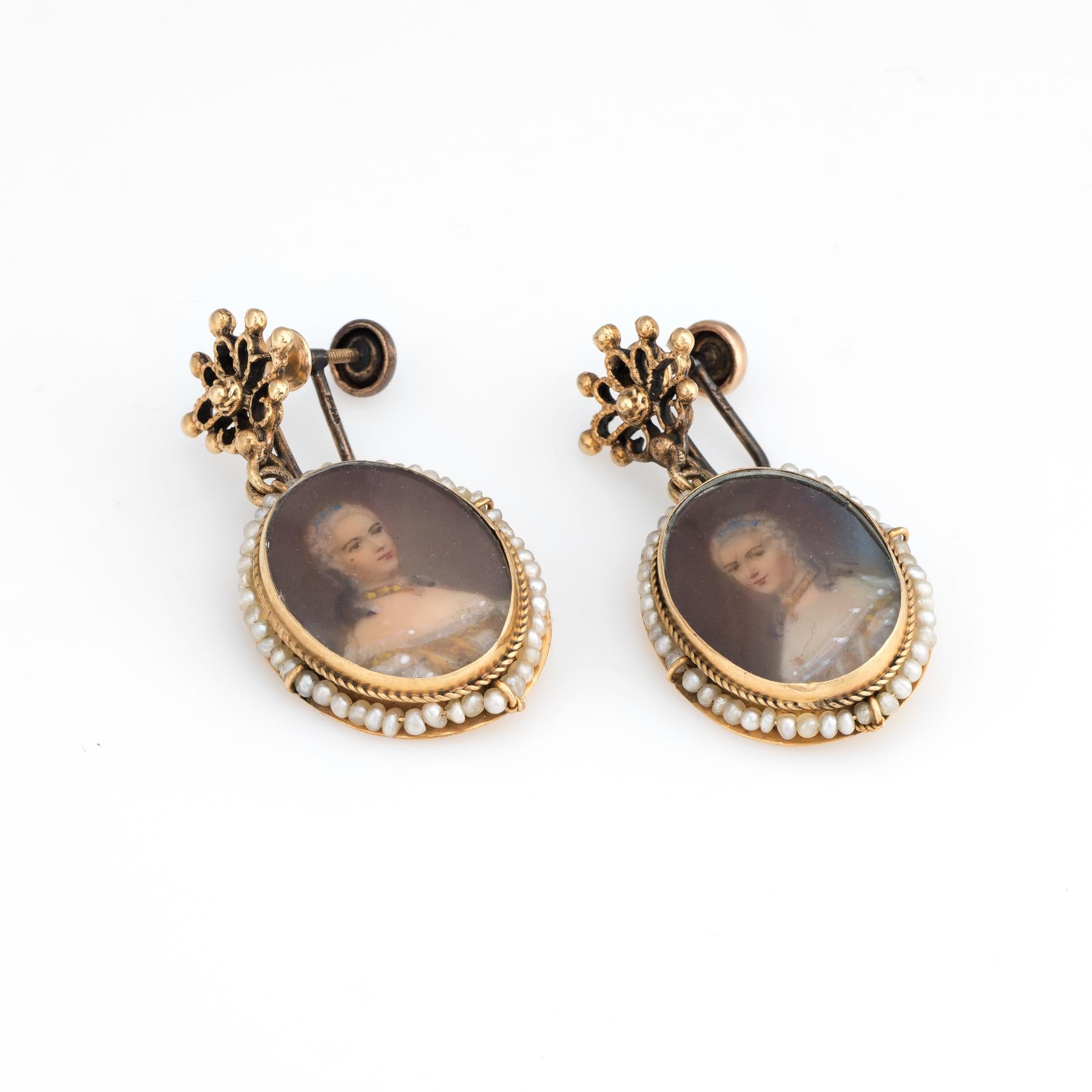 Elegant pair of vintage earrings (circa 1950s to 1960s), crafted in 14k yellow gold. 

The earrings feature a hand painted portrait of a Victorian woman on porcelain measuring 20mm x 15mm. Framing each portrait is seed pearls secured on a wire