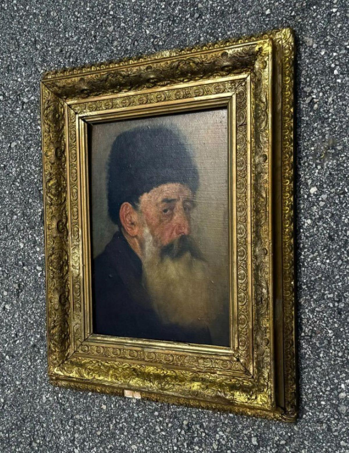 Dieses traditionell wiedergegebene Porträt zeigt einen älteren Mann in reicher Detailfülle. Sein langer, buschiger grauer Bart und die tief verschatteten Augen verleihen der Komposition Gewicht und Präsenz. 
Bekleidet mit einer dunklen europäischen