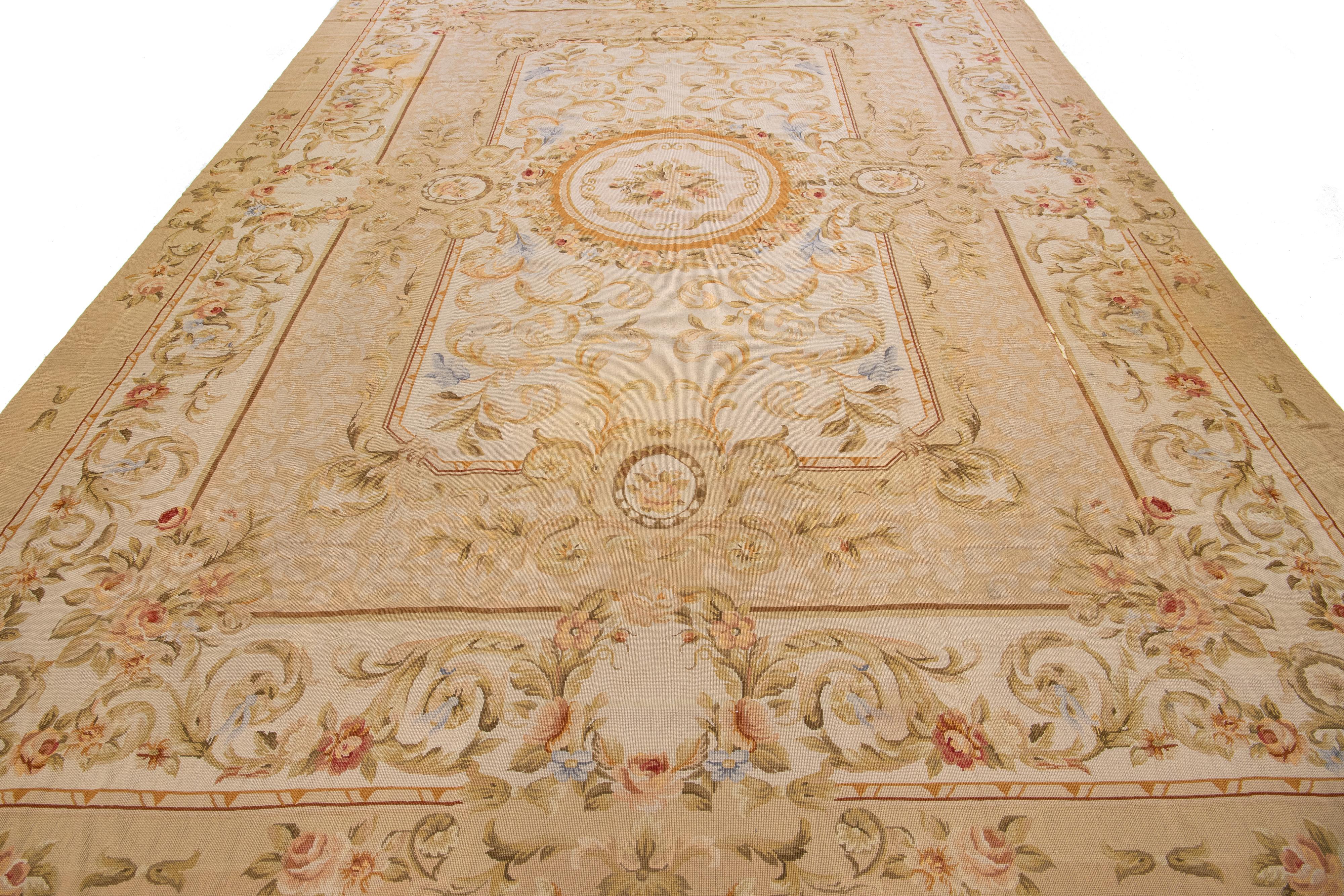 Dieser elegante Aubusson-Wollteppich im Vintage-Stil besticht durch sein beiges Farbfeld. Der Teppich ist mit fein detaillierten, exquisiten Blumenmustern über das gesamte Design verziert.

Dieser Teppich misst 9'9