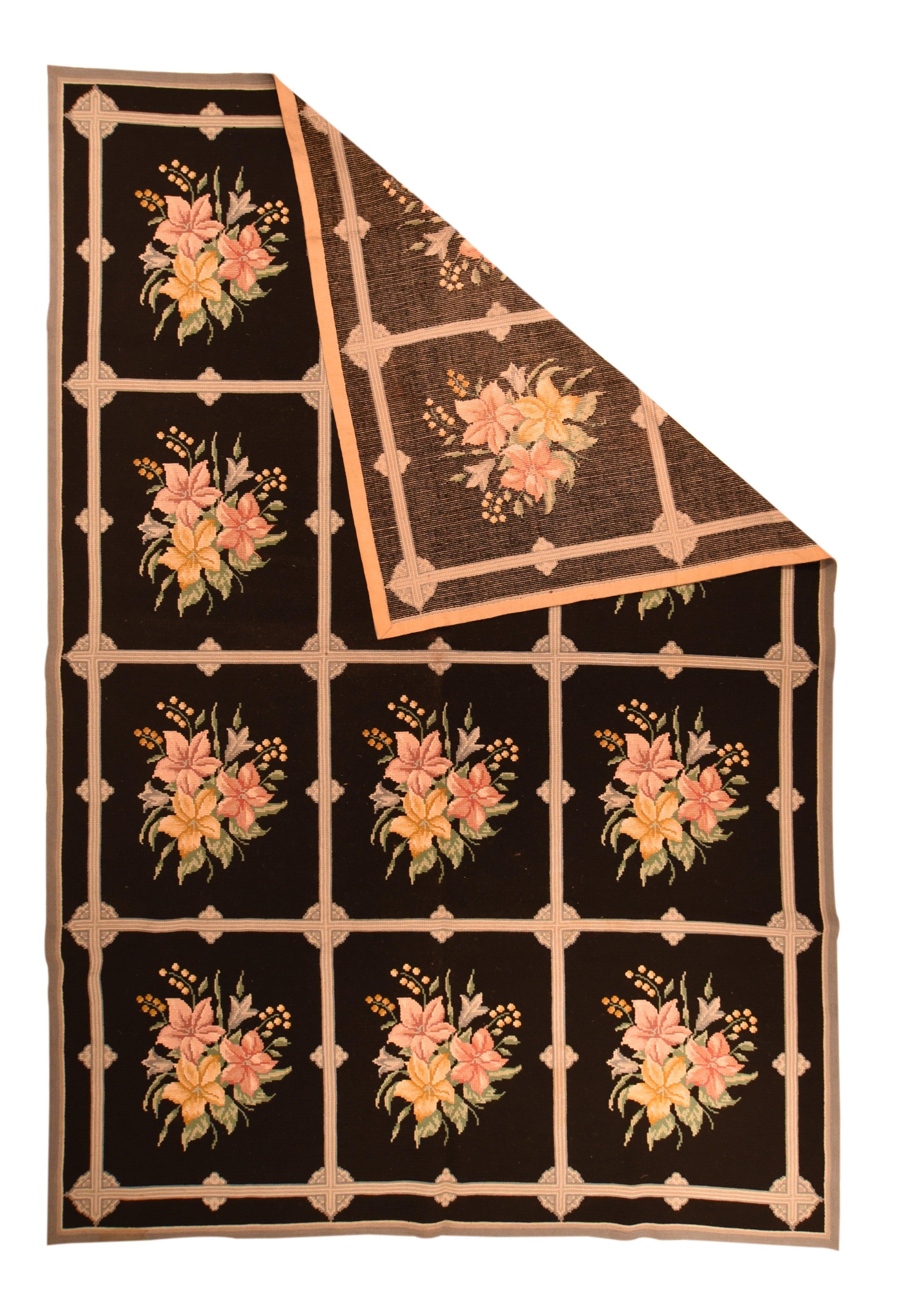 Vintage Portuguese Rug 6'8'' x 9'8''. The black field is divided by a square lattice into a three by four array of panels which identically enclose a bouquet of three similar five-petal flowers with attendant strays, buds and leaves. Details in