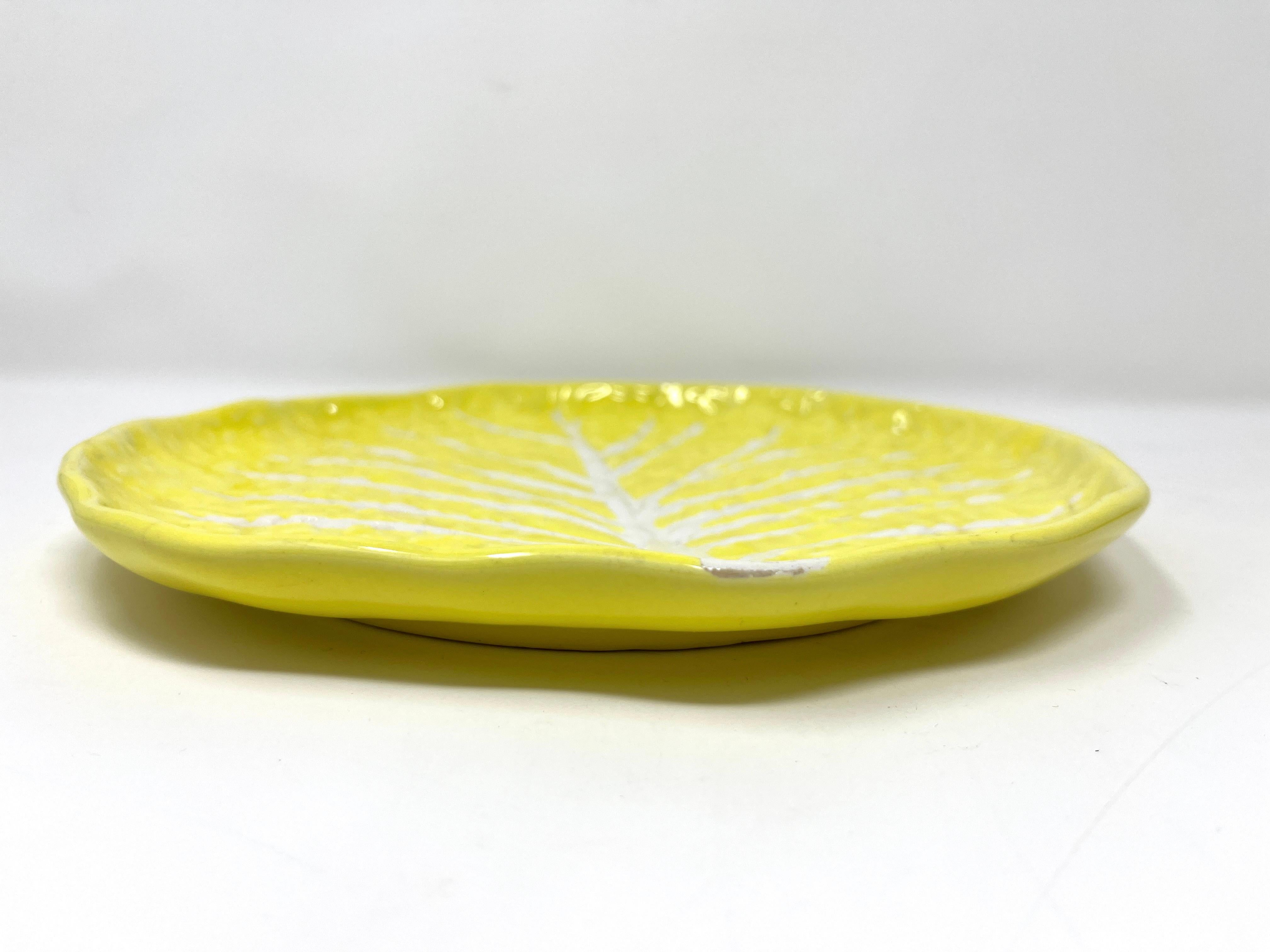 A pair of ceramic lemon-yellow color lettuce leaf plates by Secla. This wonderful pair of Portuguese plates will be a fabulous touch on your serving table. Each plate features a raised vegetal motif of the lettuce leaf, as is classic.

Stamped on