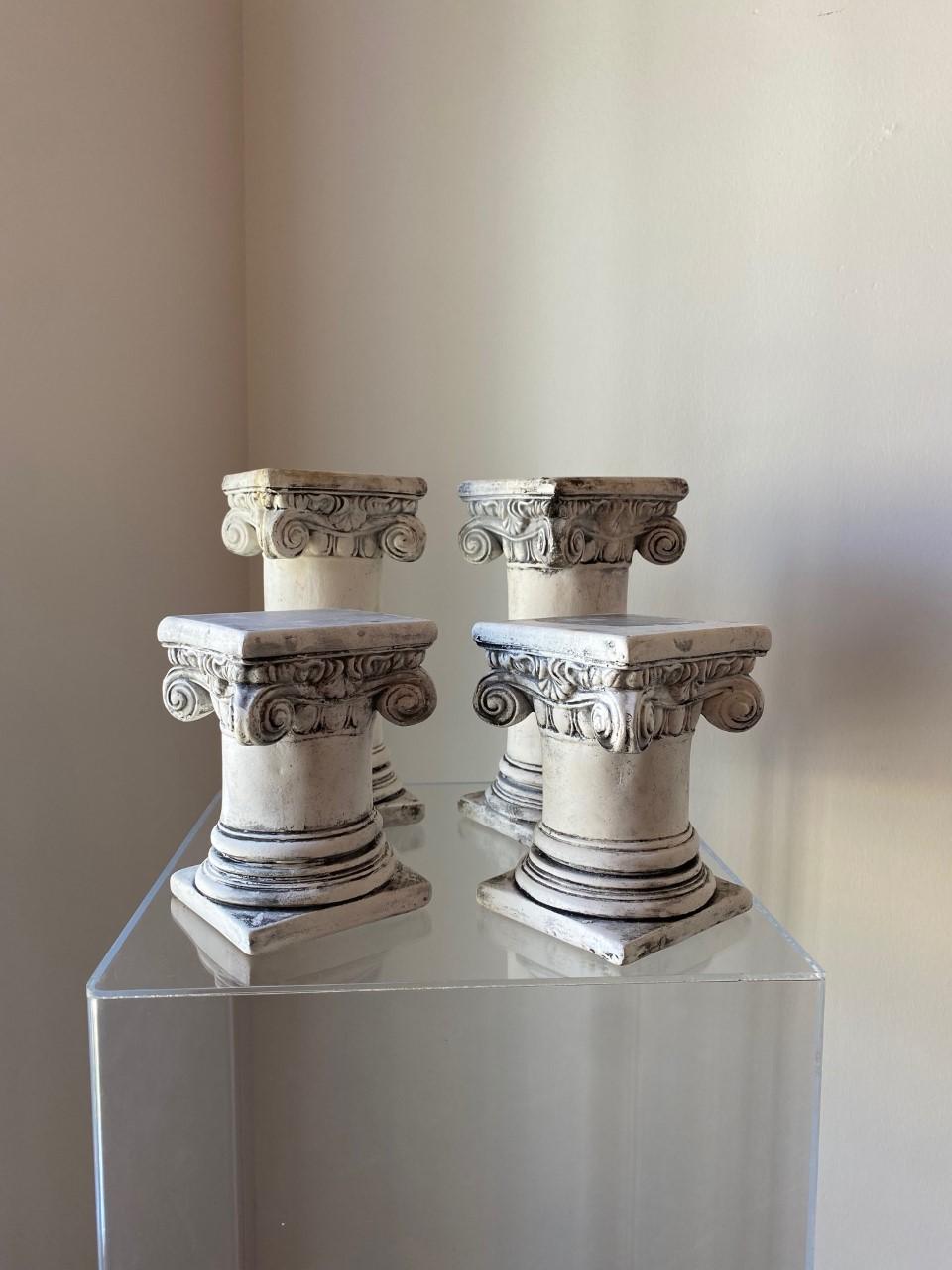 Unique and interesting set of 4 decorative plaster greek columns. These fun pieces have a variety of uses that add to their striking style and beauty. Modeled as greek composite columns, these pieces add a Classic yet edgy style to your décor. They