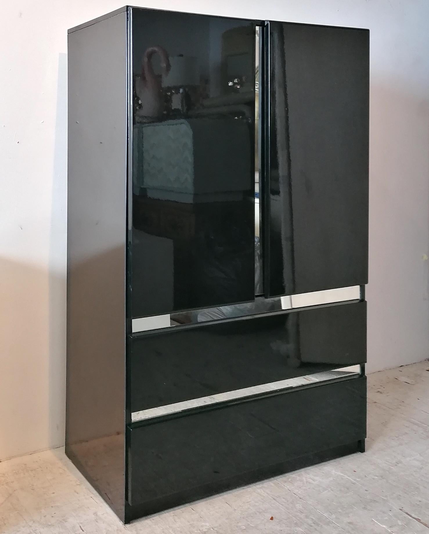 Mueble alto lacado en negro, revival decó de los años 80, de Millennium, EE.UU. Parece un borde cromado, pero en realidad es cristal de espejo. Las puertas dobles se abren a estanterías; debajo, 2 cajones grandes. En buen estado vintage- pequeñas