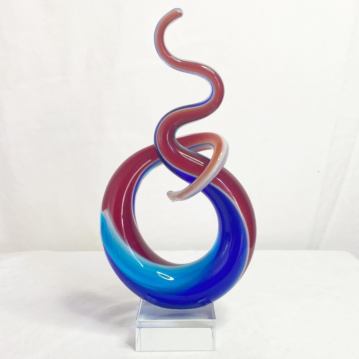 Exceptional postmodern glass sculpture on a lucite vase. Features a hand blown red and blue swirl.
 