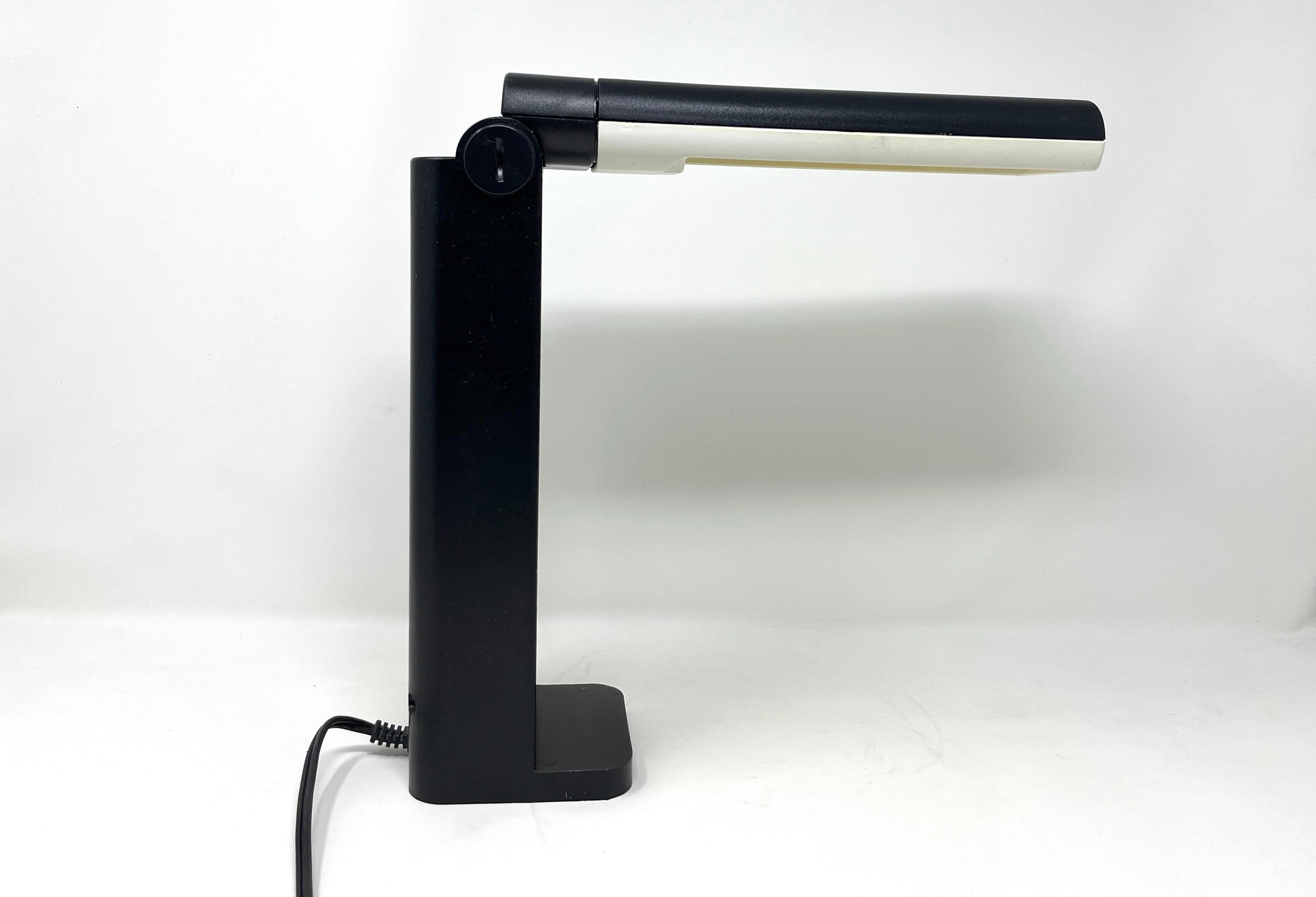 Folding post modern desk lamp made of high-impact plastic. Most likely by Marksman Brown, made in Taiwan. Marked Model #3870. 13 watt bulb, included. Features an adjustment screw to control arm tension.

Measures 10.5
