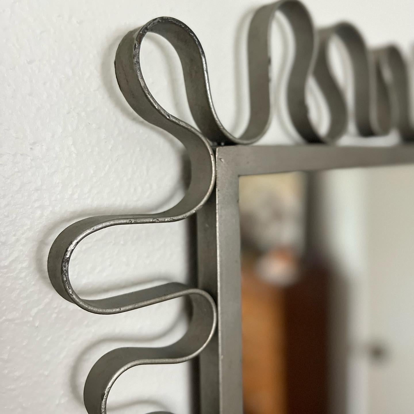 A vintage rectangular wall mirror featuring a silver iron frame in a beautiful curved design. Get you an original squiggly mirror! Can be used horizontal or vertical. In great vintage condition. Some patina and areas of paint loss to the silver