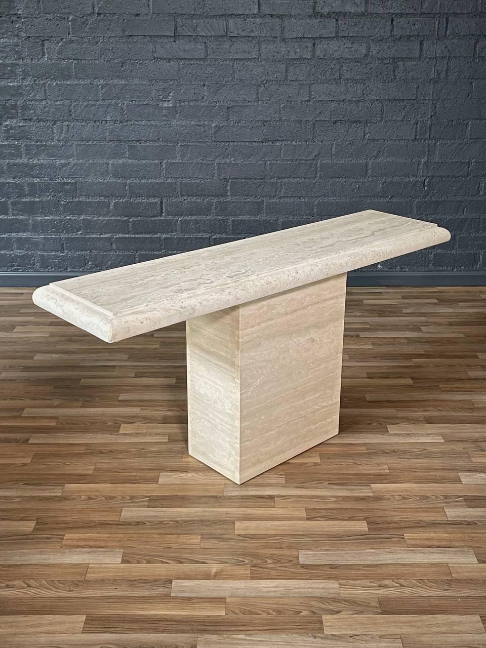 Condition: Original Vintage Condition

Materials: Italian Travertine Stone

This sculptural Italian travertine console table, made in the 1970s, brings timeless elegance with its sleek Post Modern design. Crafted from solid honed travertine, the