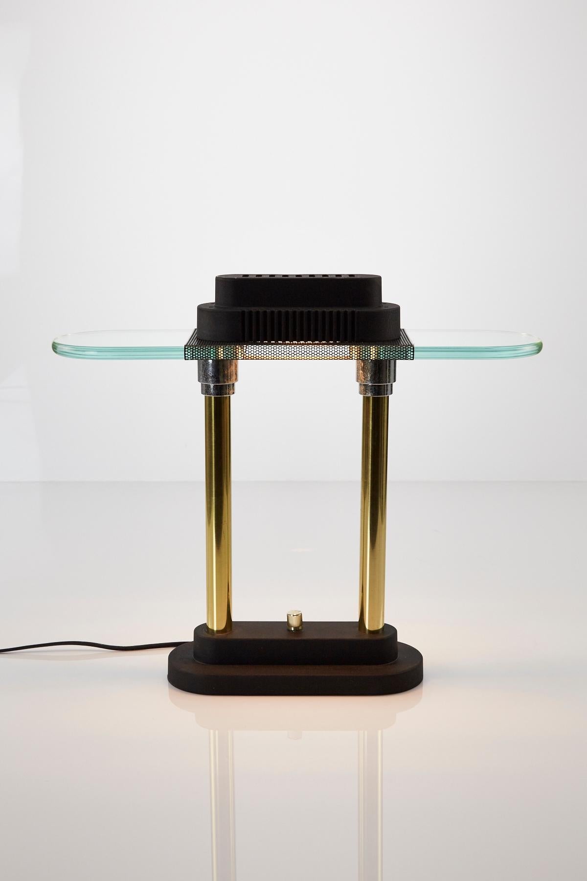 Vintage Postmodern desk or bankers lamp by Robert Sonneman for George Kovacs from the 1980s. This example features brass columns and chrome accents on a matte black base. Oblong glass shade is anchored by black metal mesh and a matte black casing.