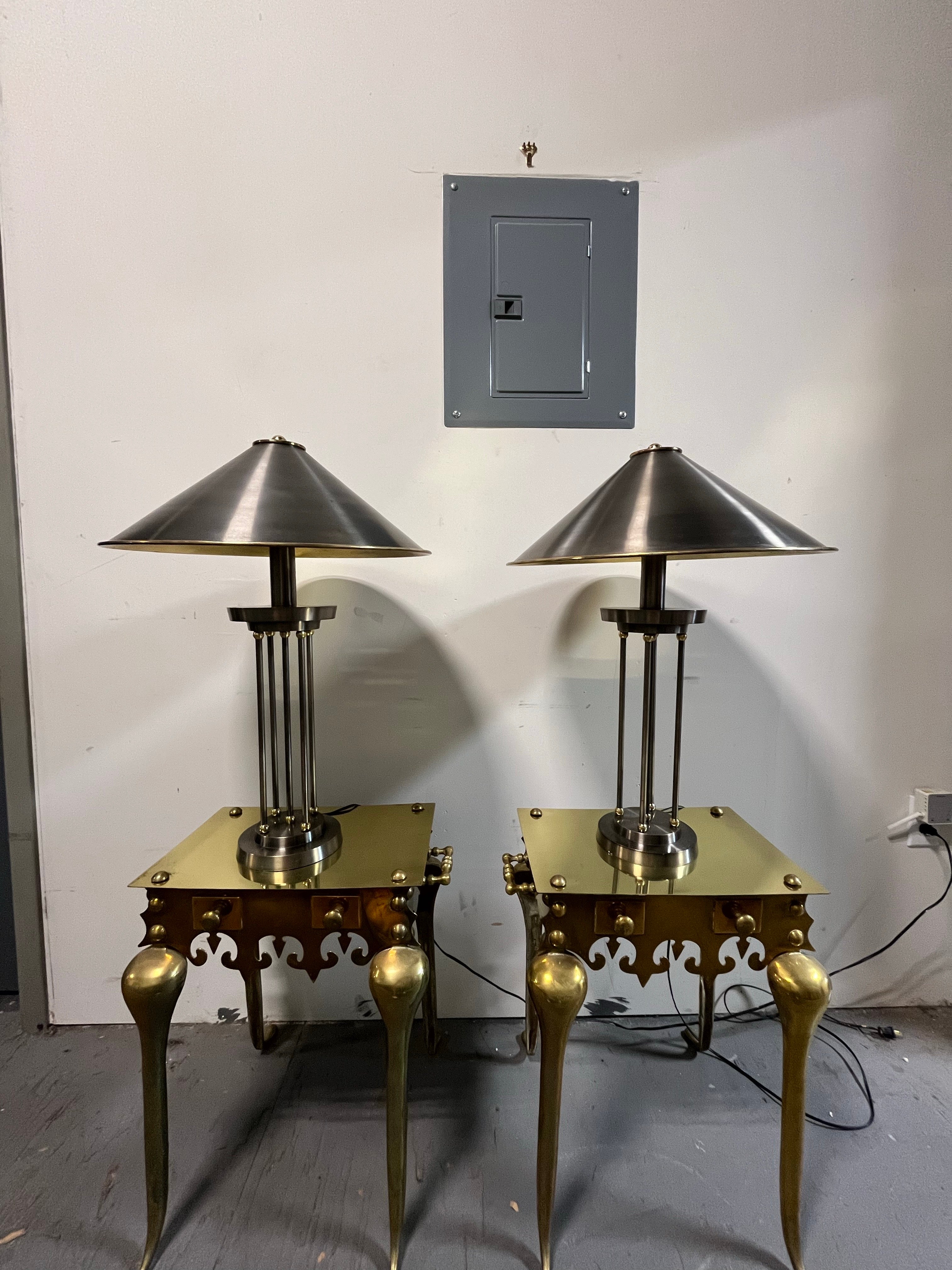 Striking post modern steel and brass columnar lamps. Dramatic presence with a metal shade topped with a heavy brass finial and brass interior to cast soft yet adequate lighting. 5 slender rods capped with brass balls sit atop a stepped circular