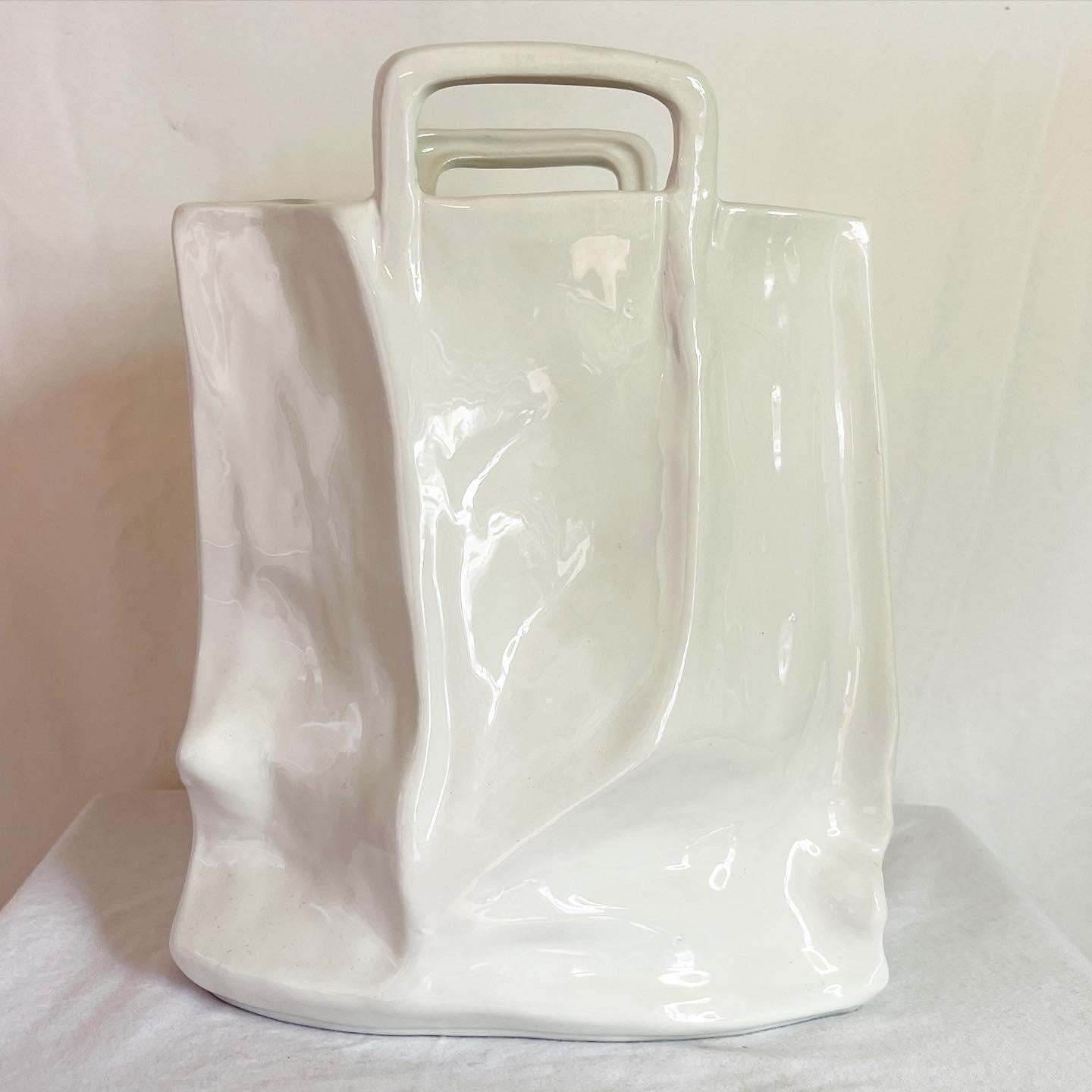 Amazing vintage postmodern ceramic sculpted vase. Subject is a glossy white bag handles.
 