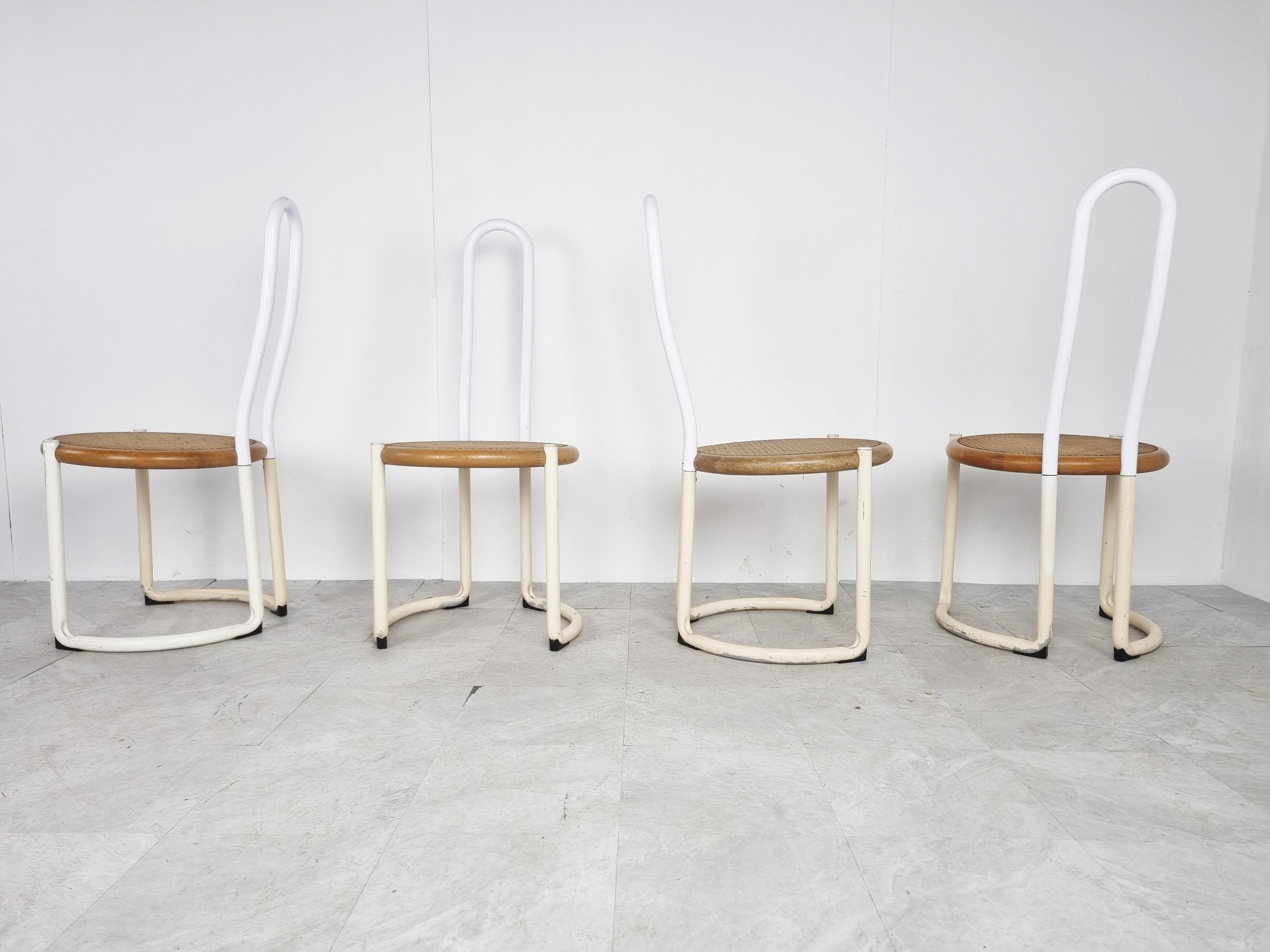 Italian metal postmodern or Bauhaus inspired design dining chairs with white lacquered metal tubular frames and beech wood and rattan seats.

Unknown designer.

Striking design.

The frames can be redone if desired, but we left them in their