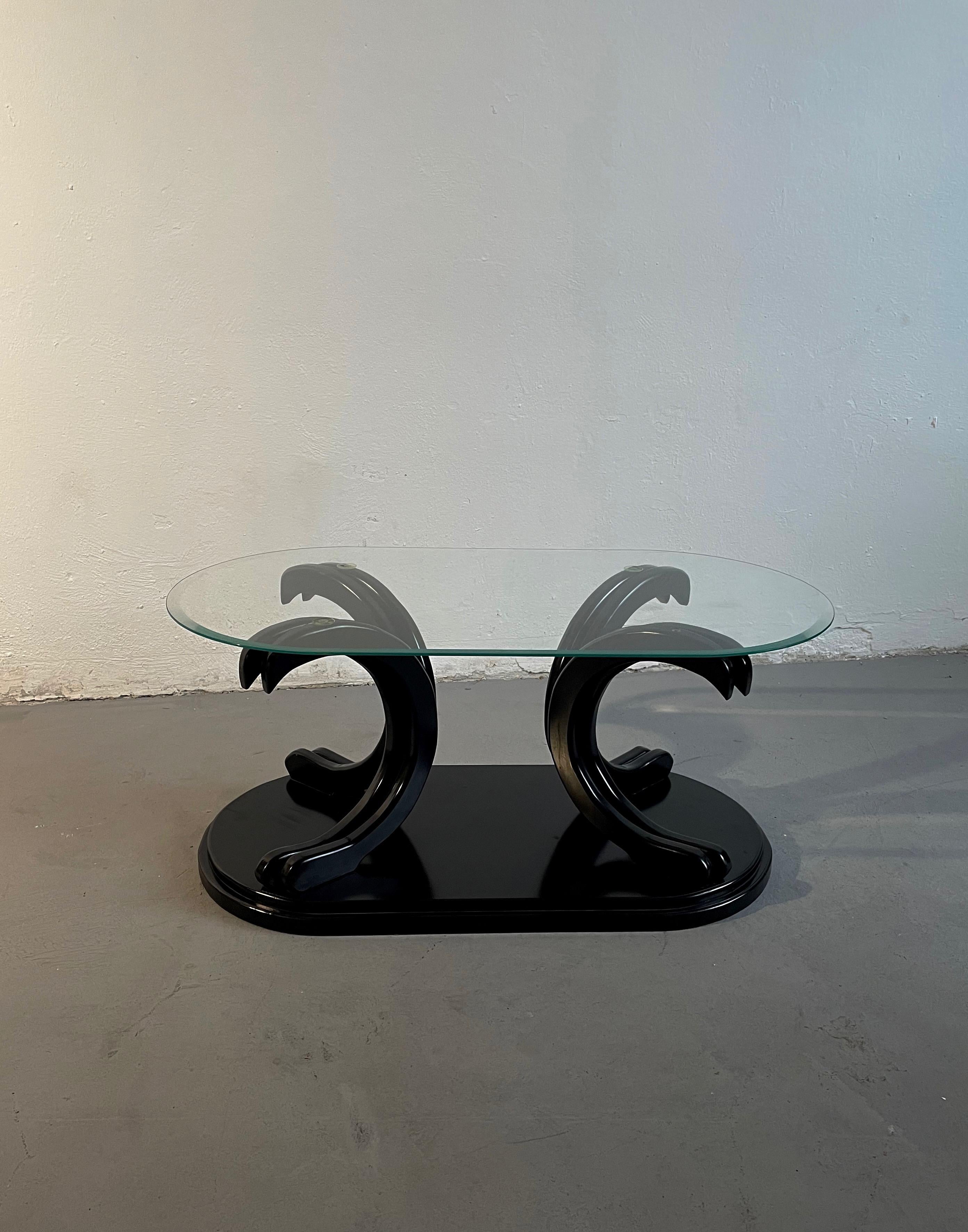 Italian coffee table produced in the 1980s.

The base is made of composite wood lacquered in black colour.

Table top is made of clear glass.

The table has some small tear and wear marks consistent with age and use. 

Total weight is 31 kg.