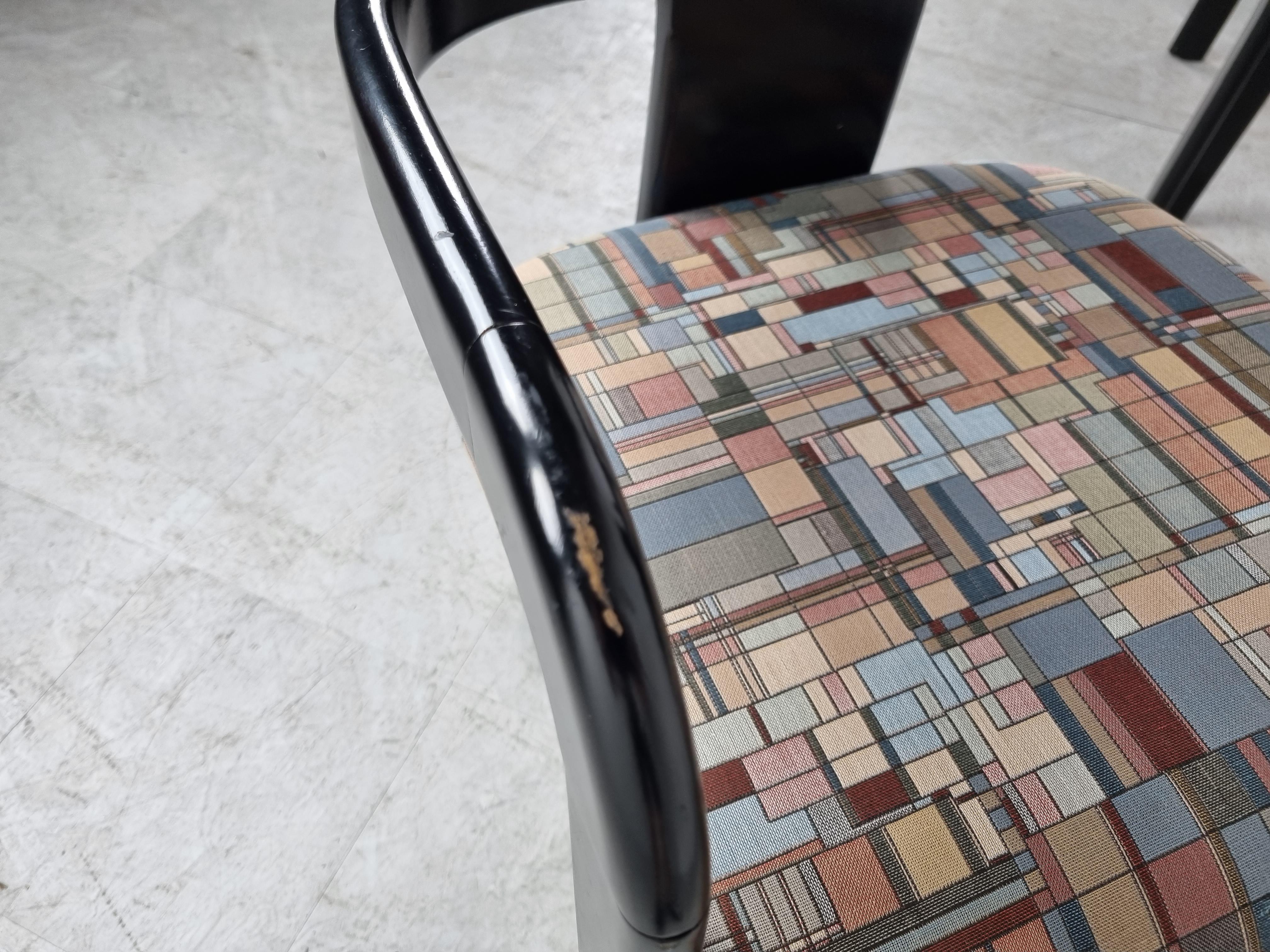 Postmodern tripod dining chairs made from a black lacquered wooden frame and a colourful gemotric fabric upholstery.

Attractive design with original fabric in very good condition.

The frames have some light wear on the armrests but still look