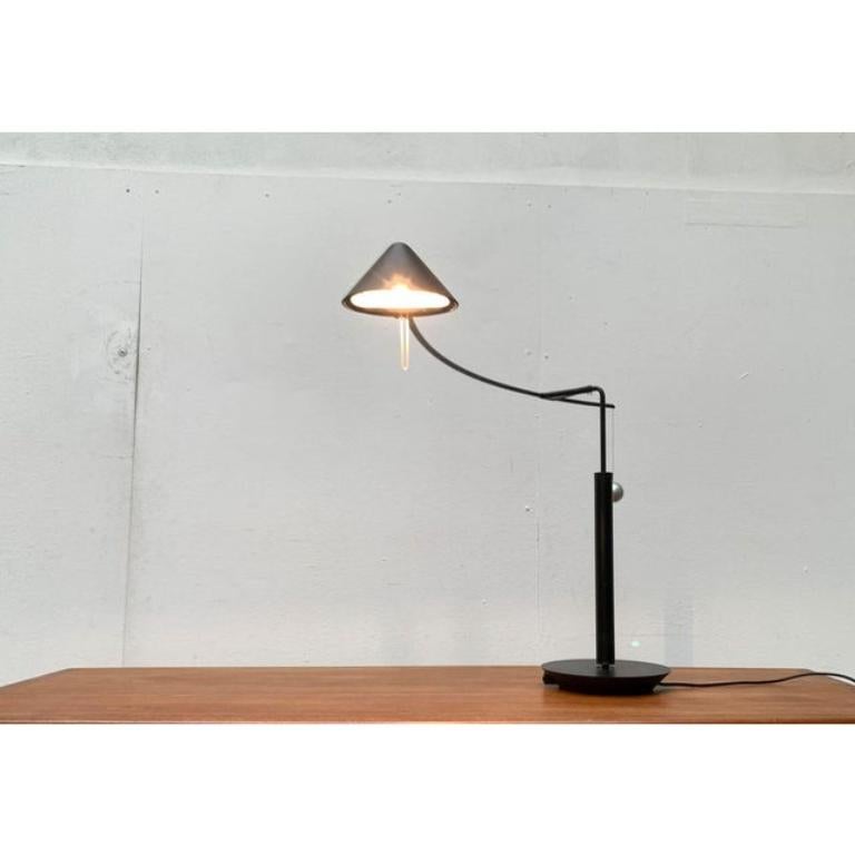 Elegante Tischleuchte des italienischen Leuchtenherstellers Artemide nach einem Entwurf von Carlo Forcolini aus den späten 1980er Jahren.

Die Leuchten der Nestore-Serie bestechen durch ihre Eleganz und eine postmoderne Formensprache. Der