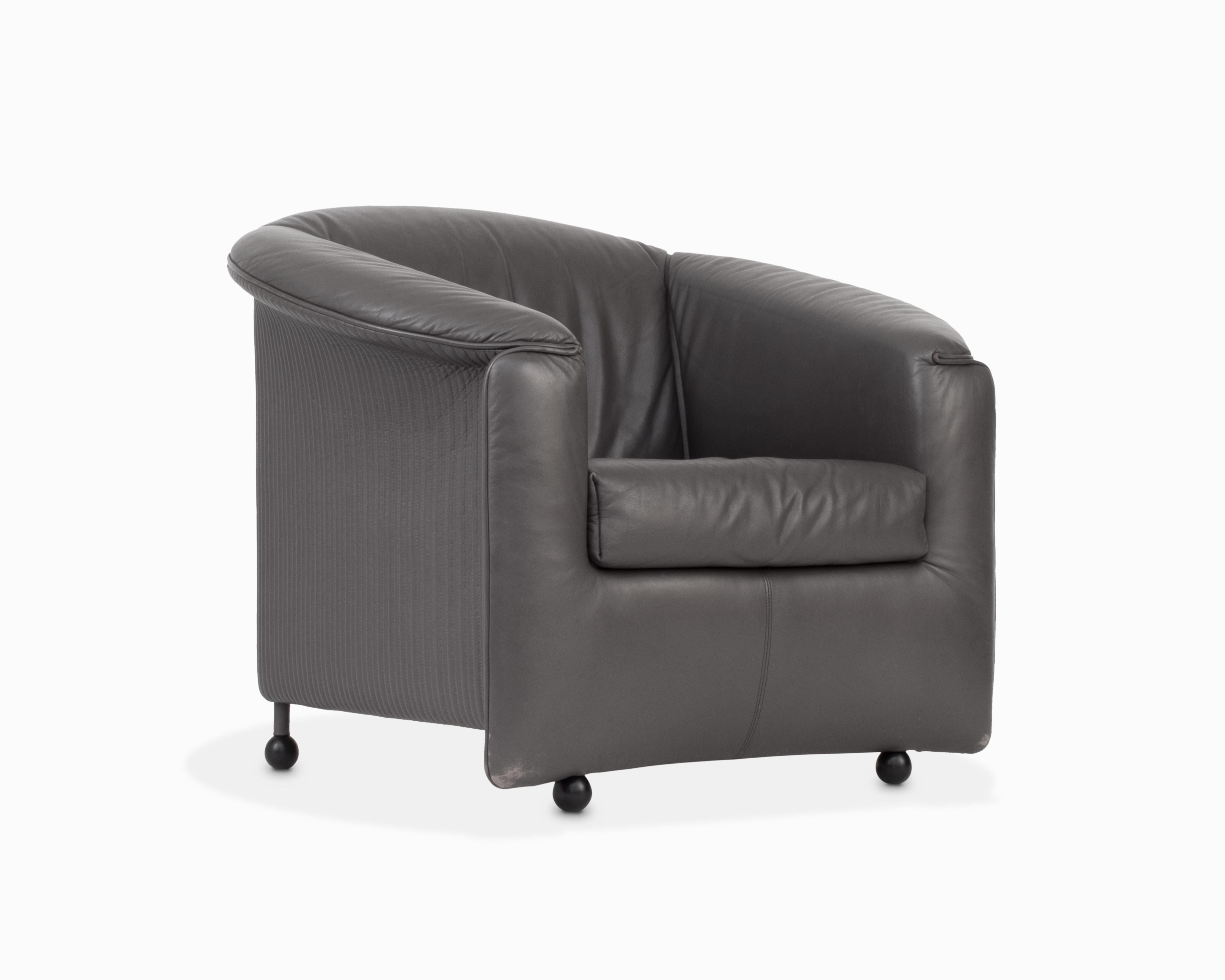 Aquí tienes una fantástica silla posmoderna de cuero de los años 80, obra de Paolo Piva para Wittman. Esta exclusiva silla de gran tamaño presenta un flexible cuero gris con detalles acanalados acentuados por pies esféricos de madera. La silla ha