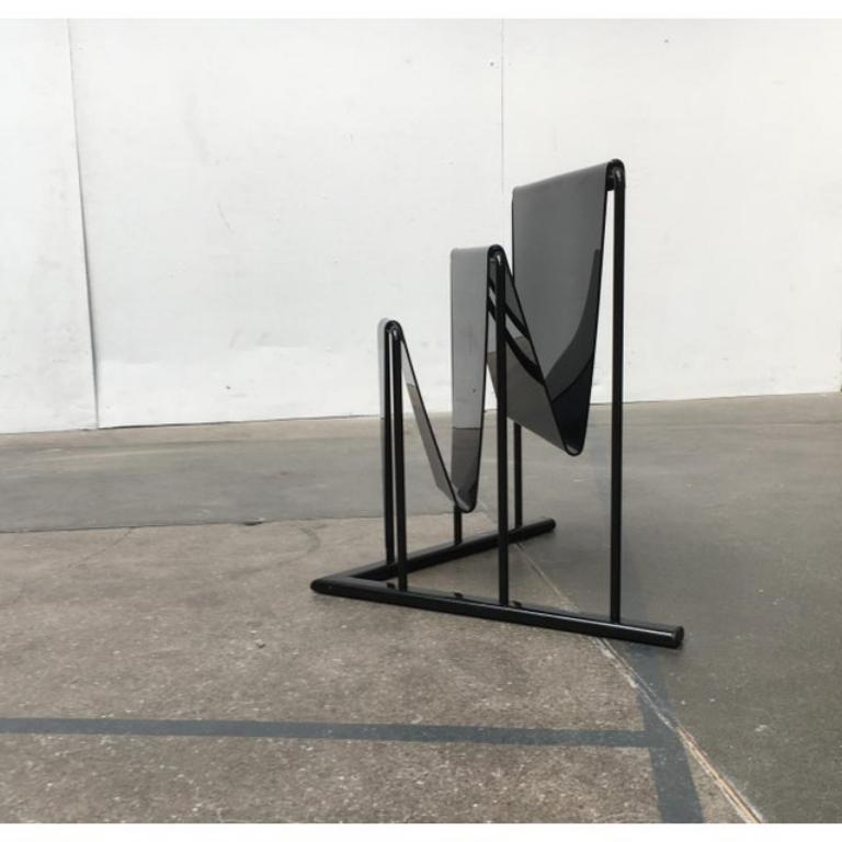 Postmoderner Zeitungsständer, Metall und Acrylglas von D-Tec, entworfen von Markus Börgens aus den 80er Jahren.

Der Ständer besteht aus zwei Elementen, dem Tragrahmen und der Statorfläche. Der Fuß ist ein dreieckiger Metallrahmen gestaffelt Bügeln