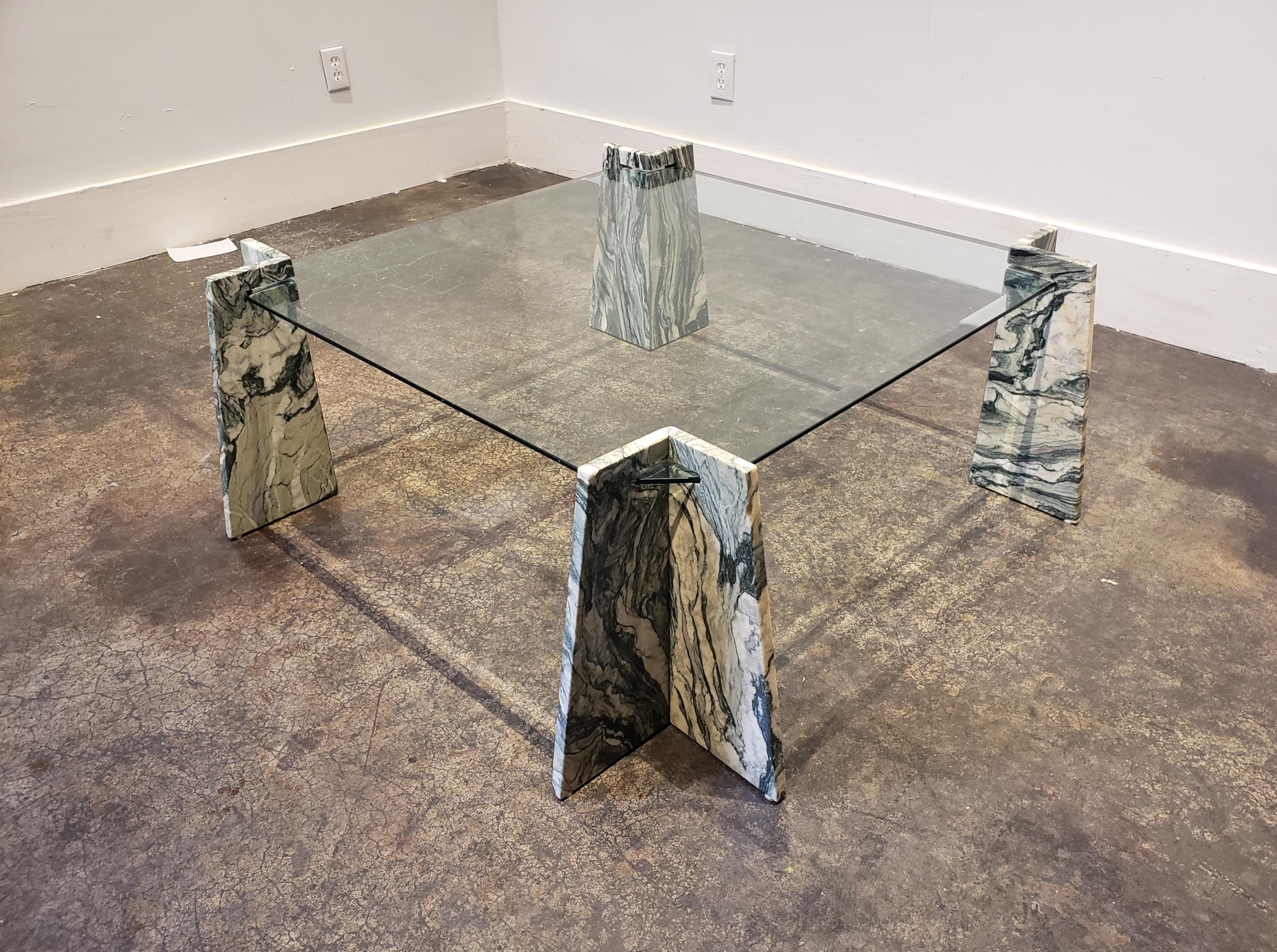 Postmodern glass and marble table with cut green marble legs and beveled glass top. Top slides into groves in the tapered V-shaped legs. Overall good condition with light wear.
Dimensions: 42