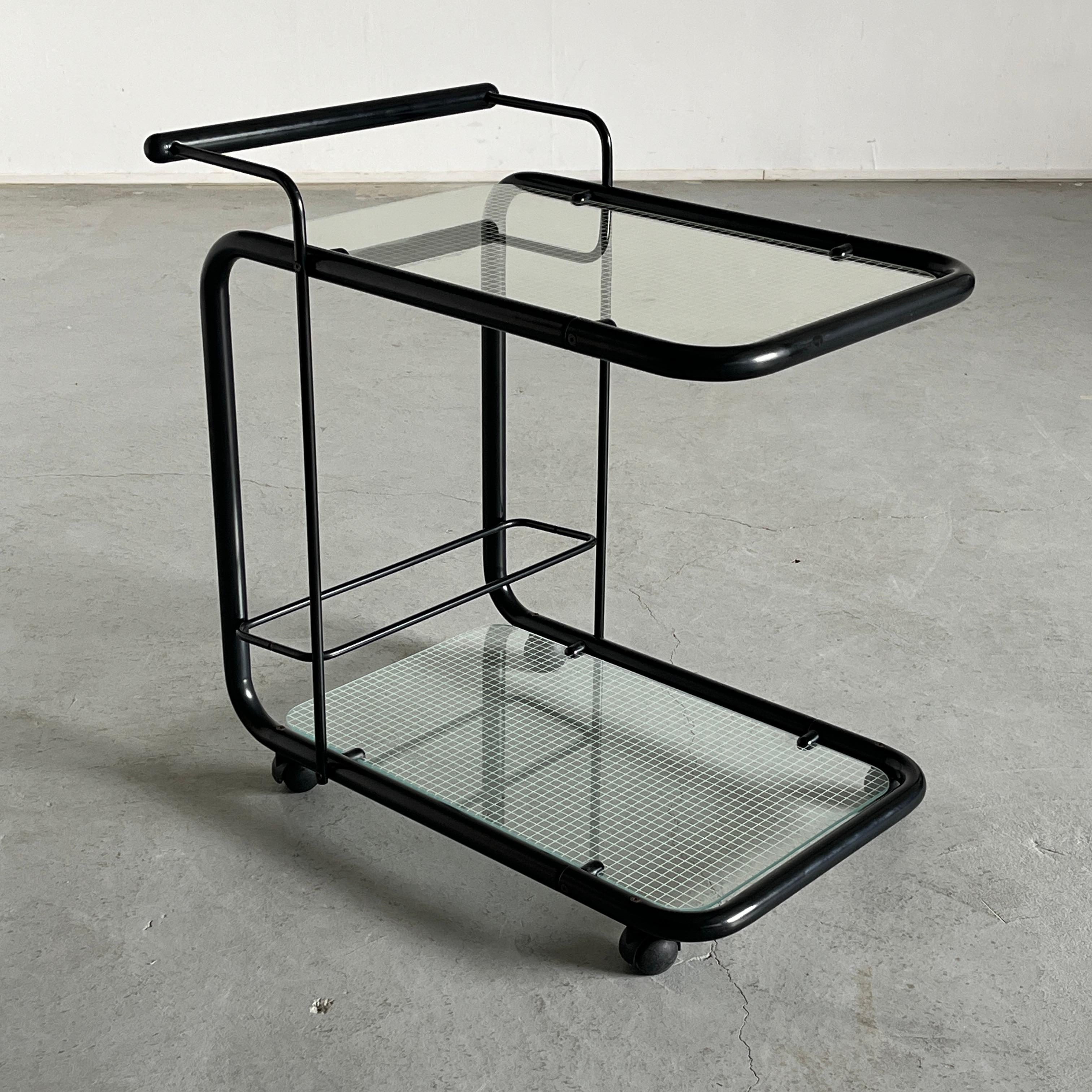 Carrello bar o carrello di servizio postmoderno vintage in stile Memphis dell'iconico produttore italiano Bieffeplast di Padova. Due piani in vetro con griglie geometriche (quaderna) poggiano su una struttura metallica nera curvilinea. È presente