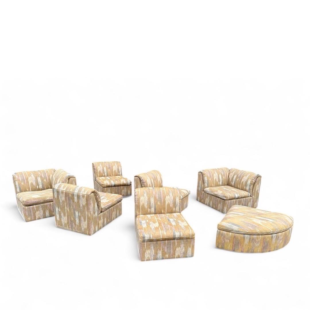 Vintage 1980’s 7 piece modular sectional sofa. Upholstered in Soft neutral tone textured abstract fabric, set contains two corner pieces, three armless pieces and one triangle shaped ottoman. Flexible configuration options, pieces can be used
