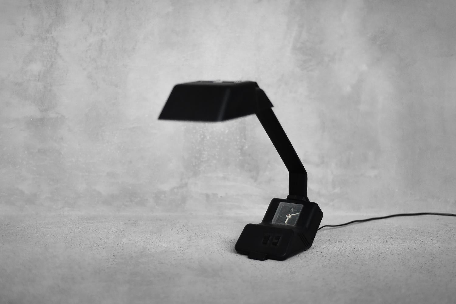 This iconic Type 27.B.101 desk lamp was designed by Wojciech Dybek for POLAMP - FSOiUT PUŁTUSK in 1987. The lamp is made of black plastic. It has two light points activated by separate switches located on the base. The lamp is also equipped with a