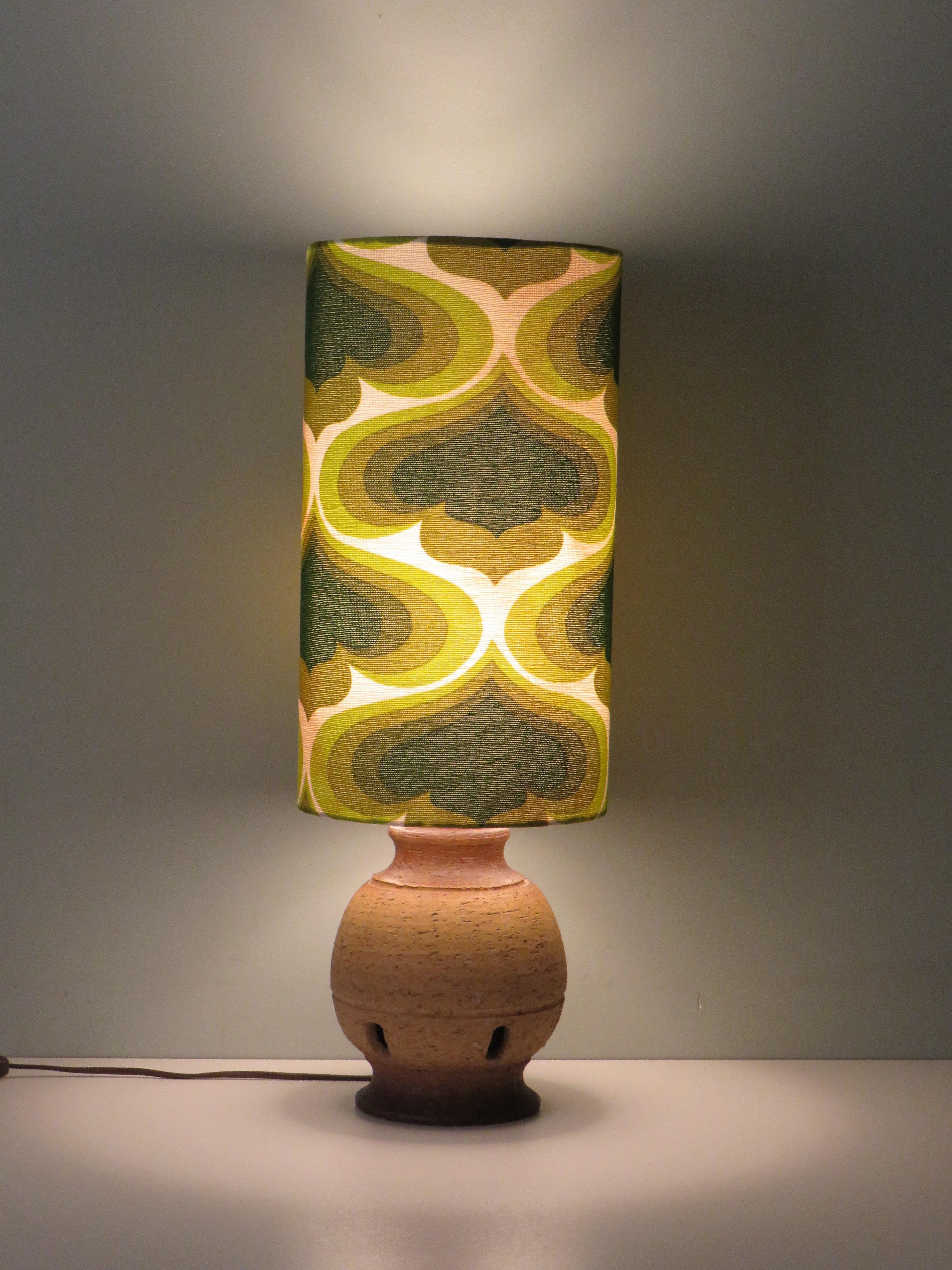 Lamp base from Massive Belgium made of unglazed natural earthenware with 5 rectangular recesses.
The lampshade is made to measure from a vintage fabric with a Space age motif with green tones on a cream-colored background.
The lampshade is 40 cm