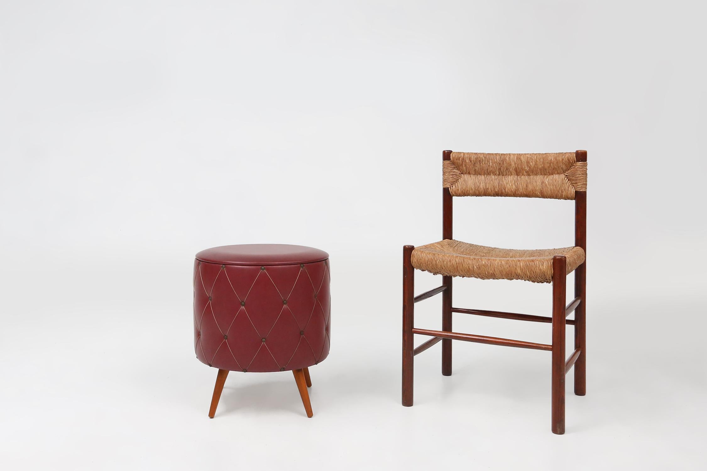 France / 1950 / pouf with storage / faux leather / mid-century / vintage

Vintage pouf made of dark red artificial leather with a padded look. At the bottom, the ottoman rests on four wooden legs. This handy storage ottoman has a removable red