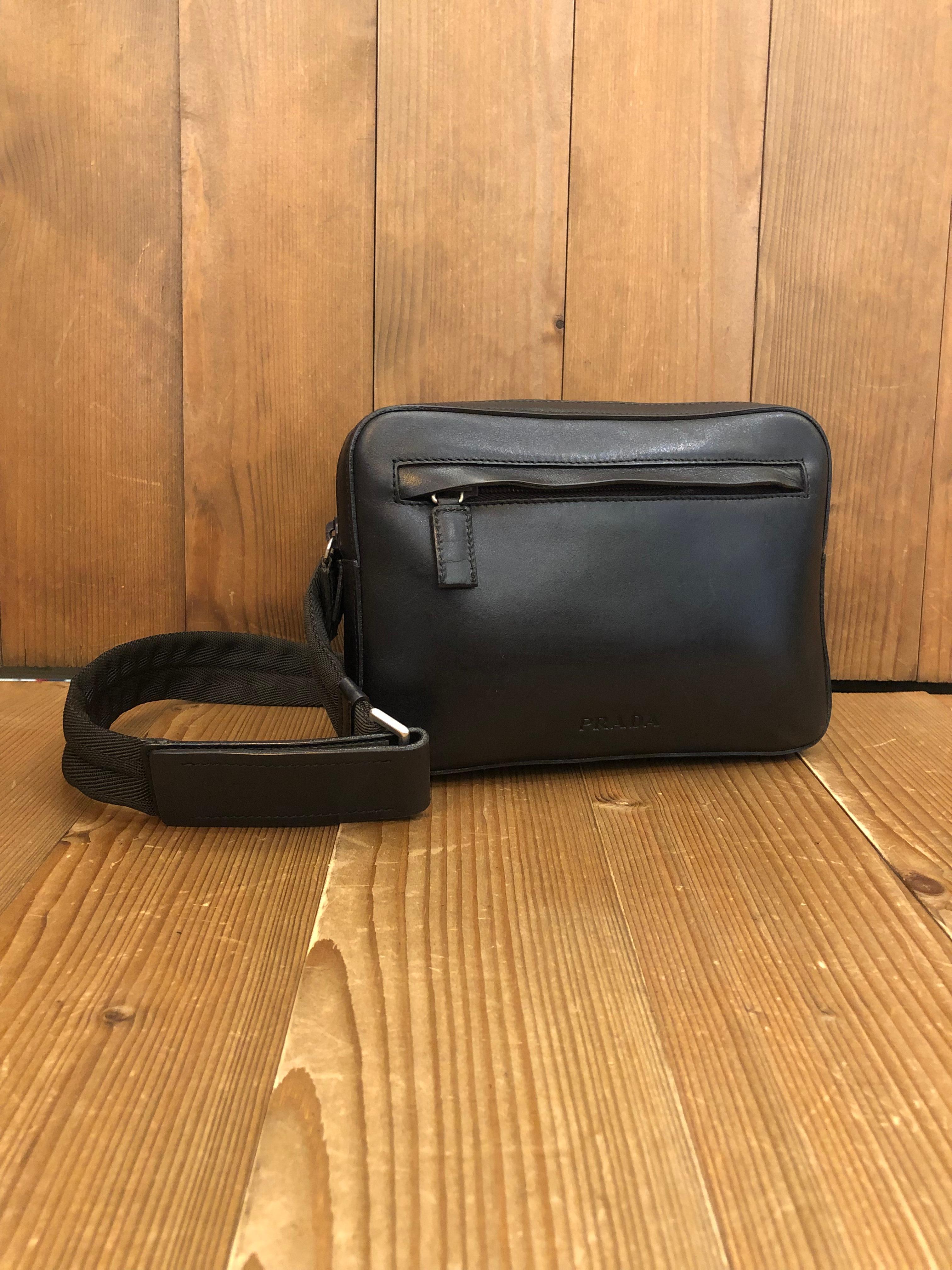 This vintage PRADA belt bag is crafted of calfskin leather in black featuring a front front zippered pocket. Top zipper closure opens to a black jacquard interior. Made in Italy. Detachable belt with Velcro closure. Bag measures approximately 8 x 6