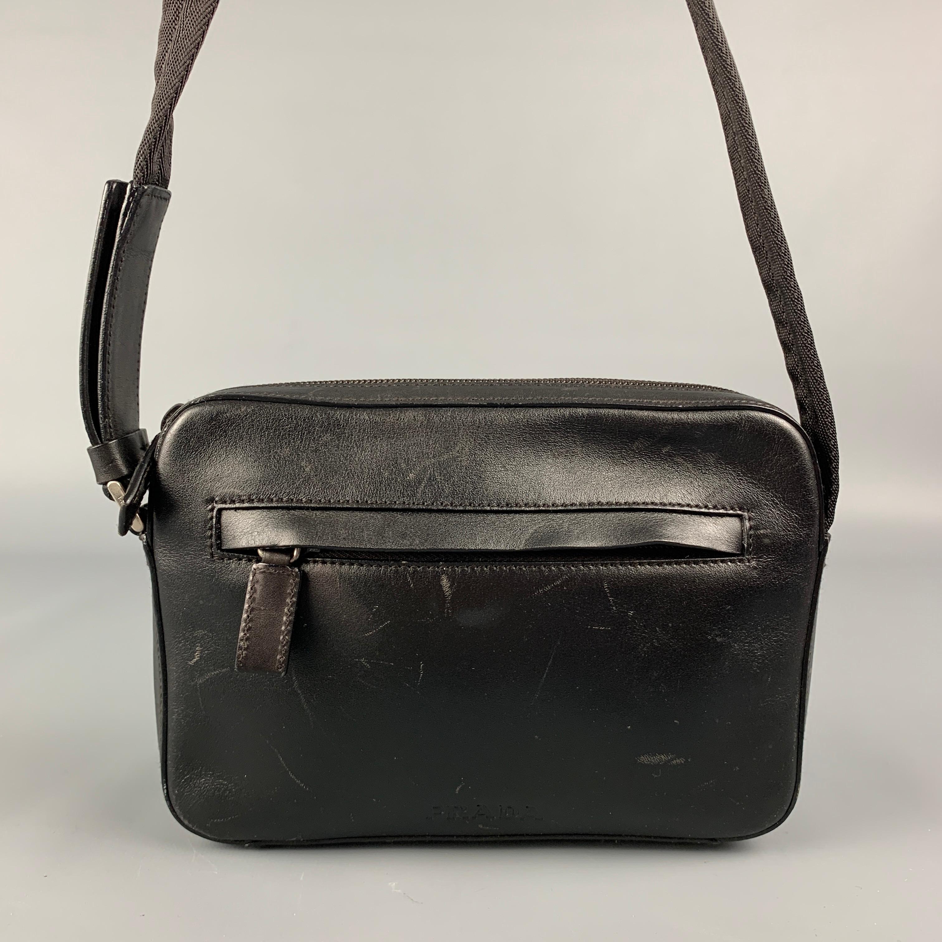 Vintage PRADA handbag comes in a black leather featuring a cross body strap, front zipper pocket, inner compartment, and a top zipper closure. Made in Italy. 

Good Pre-Owned Condition. Moderate marks throughout.
Marked: 53

Measurements:

Length: