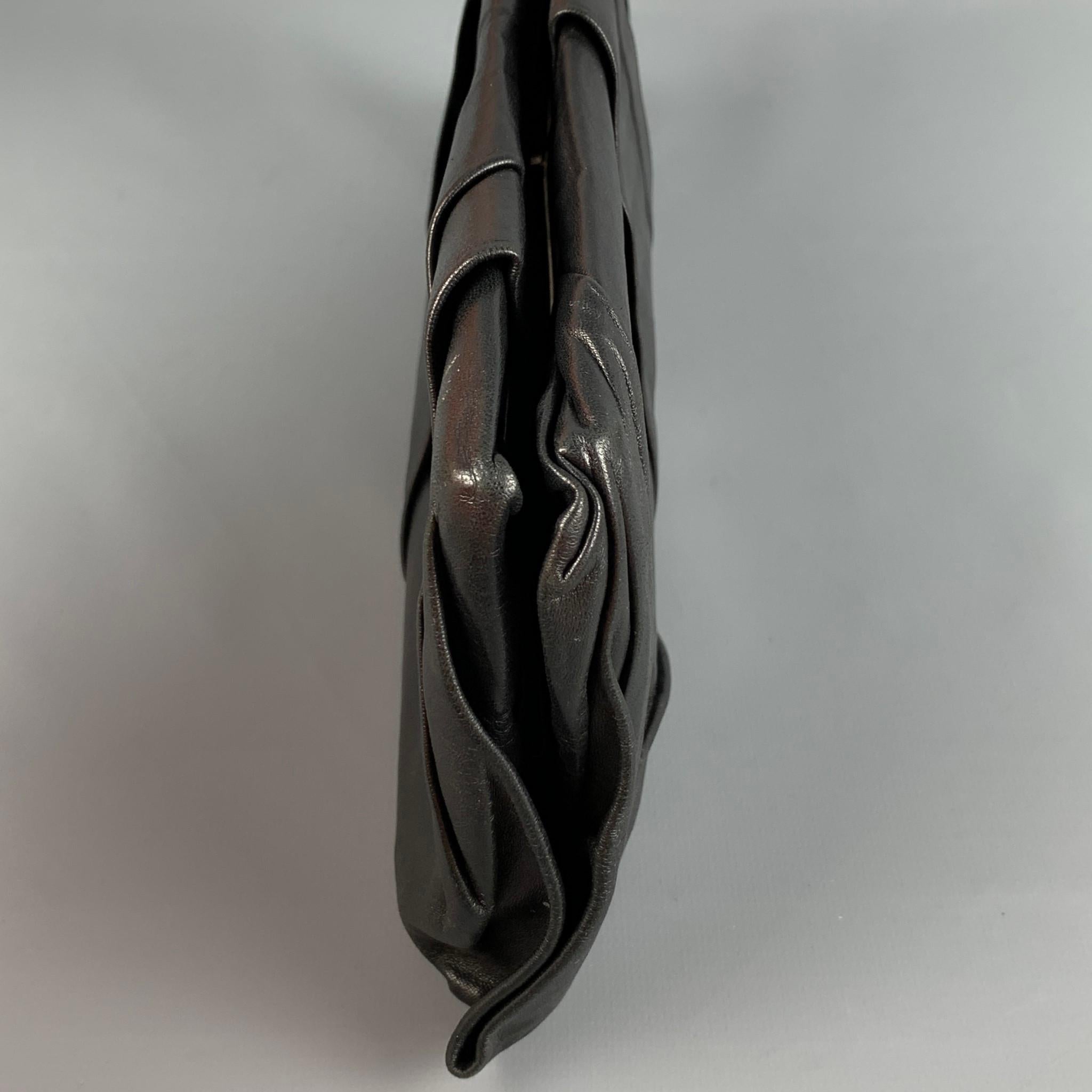 Vintage PRADA clutch comes in a black pleated leather featuring a front emblem detail, inner pocket, and a clasp closure. Includes authenticity cards. Made in Italy. 

Very Good Pre-Owned Condition.
Marked: 29

Measurements:

Length: 14.5 in.
Width: