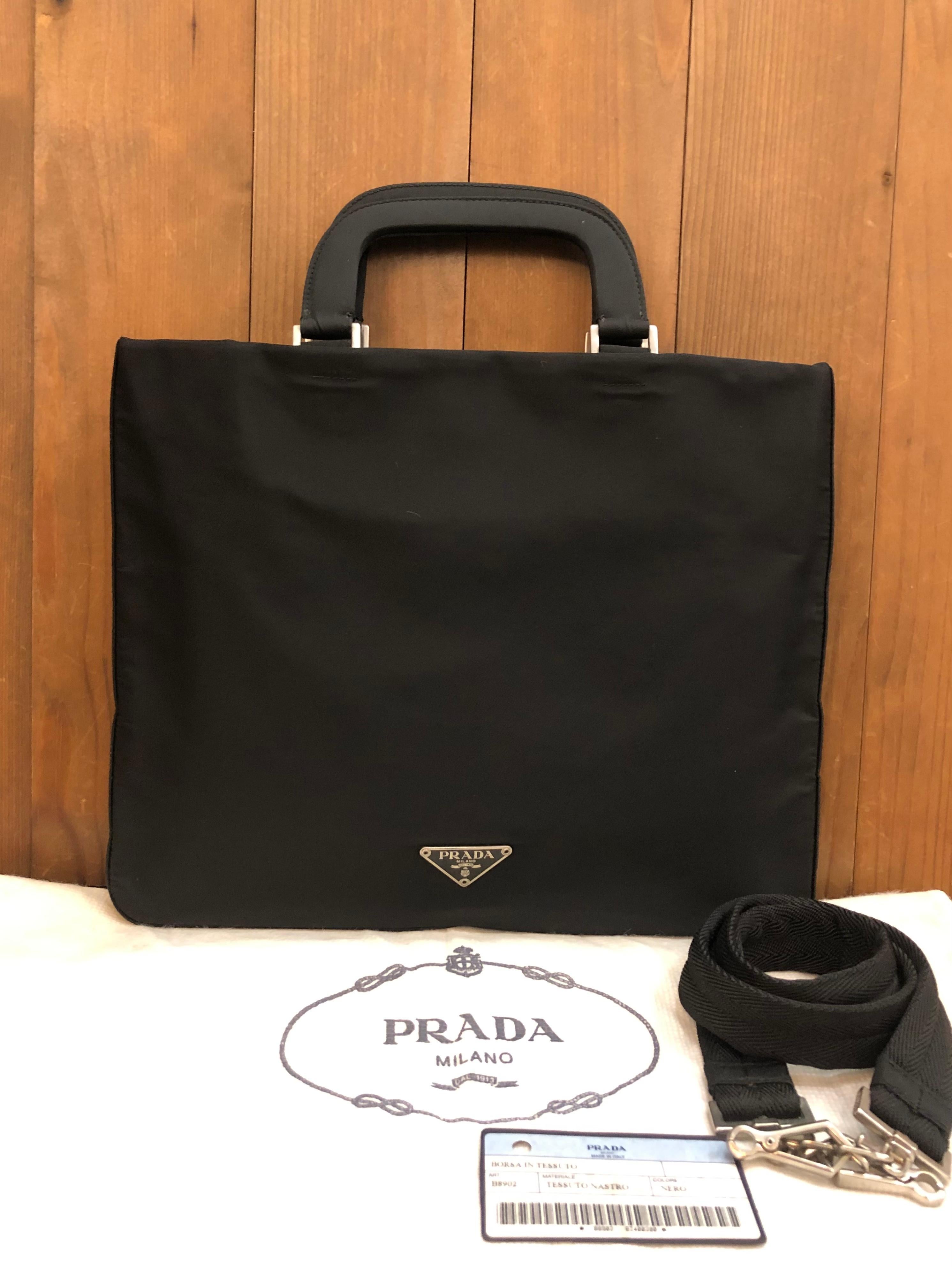 This vintage PRADA small document tote bag is crafted of black Tessuto polyester fabric and stainless steel hardware. This Prada document tote features a interior zippered pocket. It is the perfect mini bag to keep your iPad and small personal