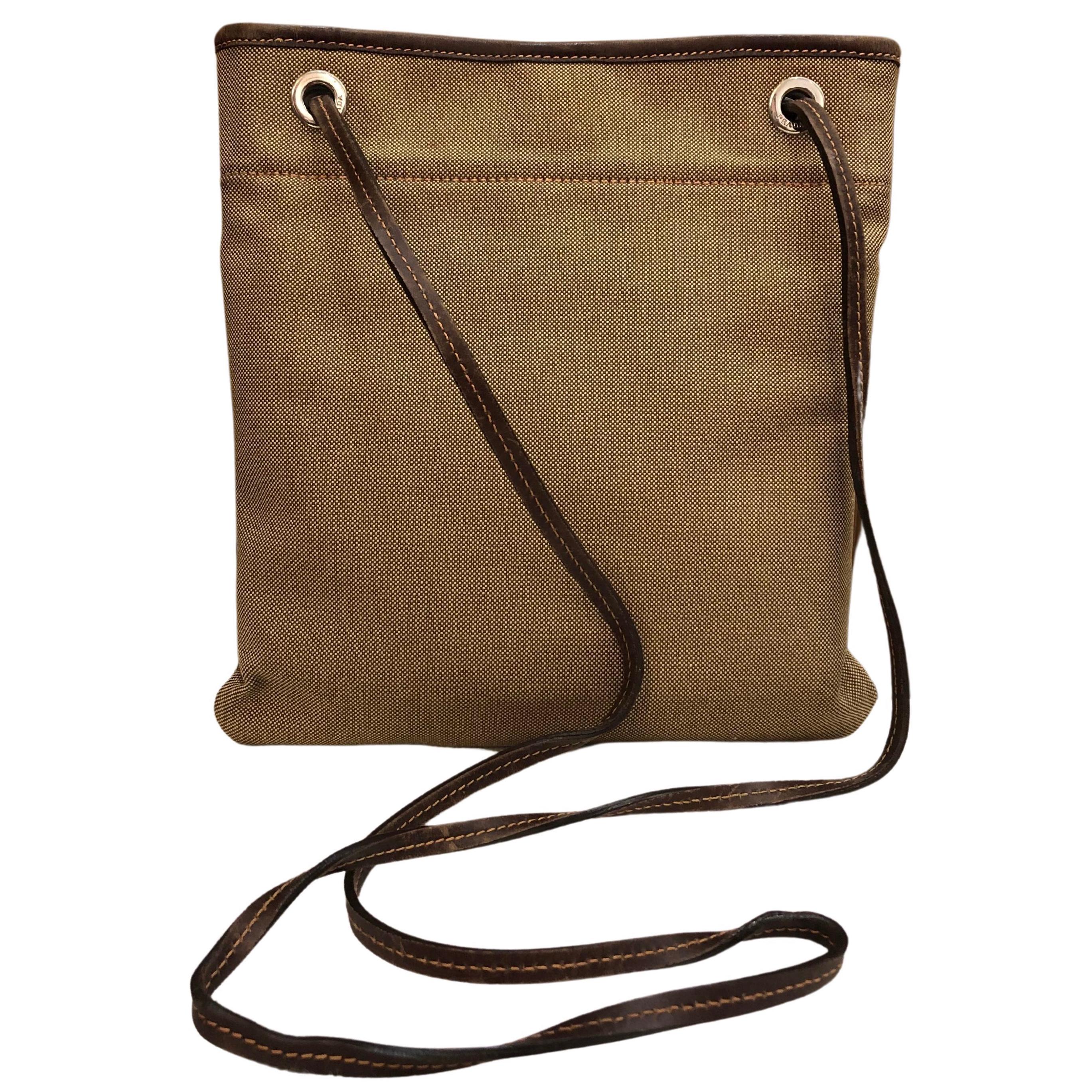 This vintage PRADA flat crossbody bag is crafted of Prada’s jacquard in brown and brown leather trimmings. Top magnetic snap closure opens to an unlined interior featuring a zippered pocket. It is the perfect crossbody bag for a casual day out or