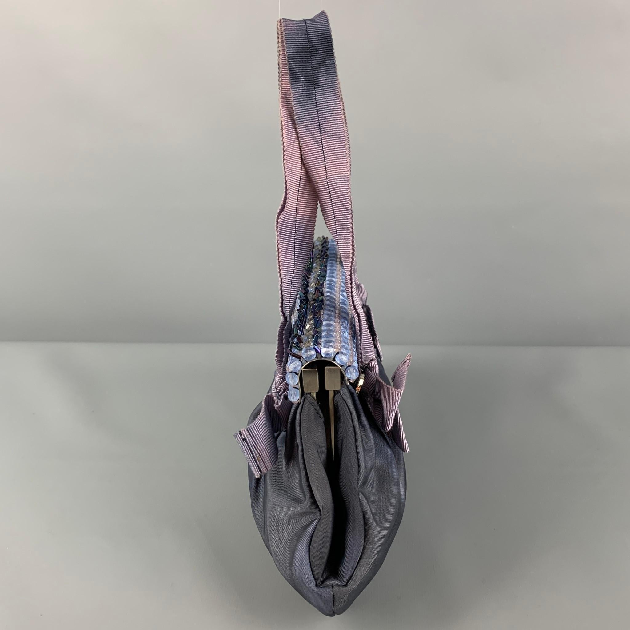 Vintage PRADA mini handbag comes in a purple marbled silk featuring a ribbon top handles, rhinestone panel design, sequin trim, logo emblem detail, inner pocket, and a magnetic closure. Made in Italy. 

Good Pre-Owned Condition.
Marked: