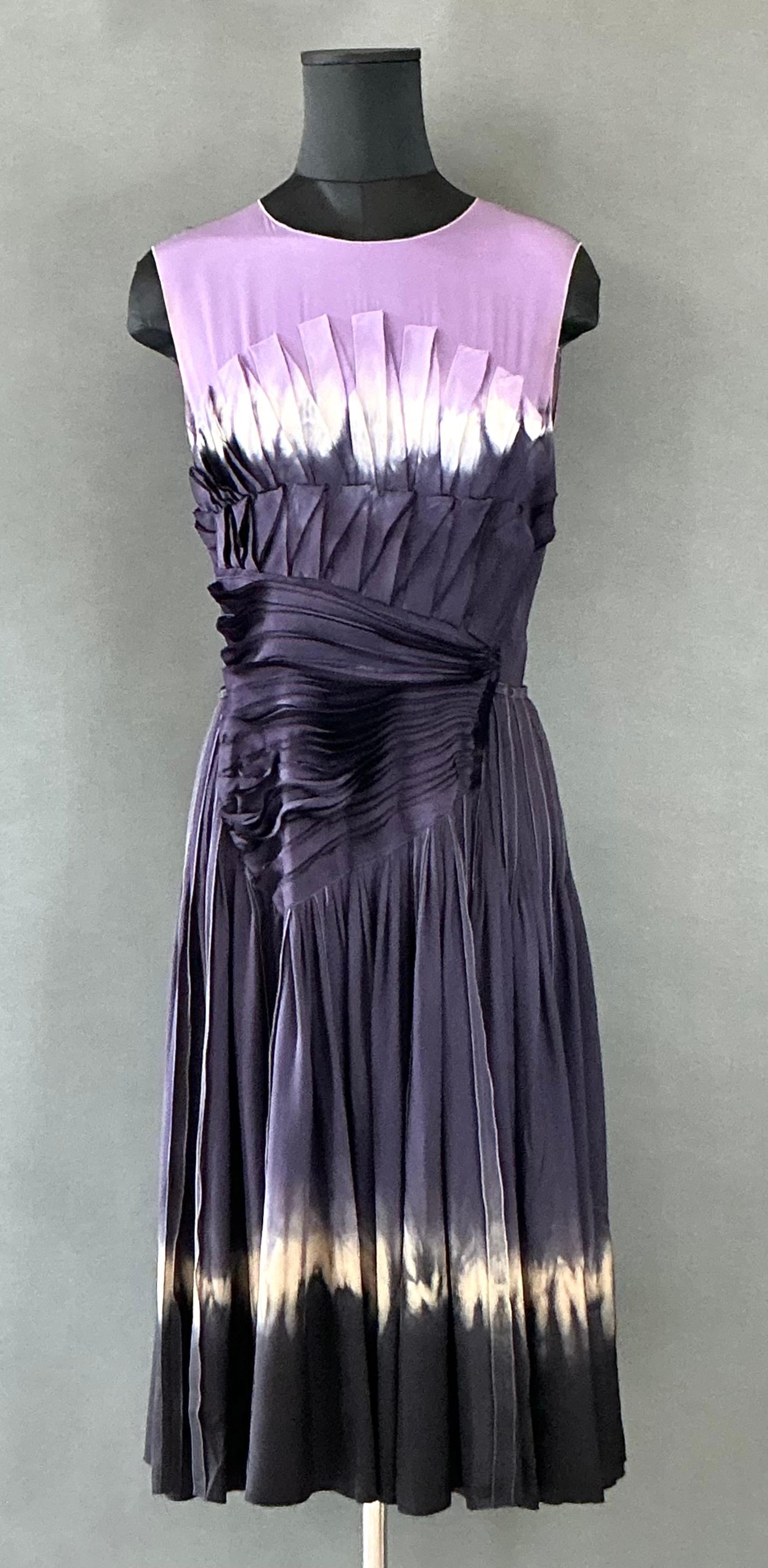 This Vintage Prada Shibori Dyed Dress is a distinctive and artistic garment that beautifully reflects the avant-garde spirit and commitment to craftsmanship. Shibori, known for pushing the boundaries of fashion and art, often incorporates bold