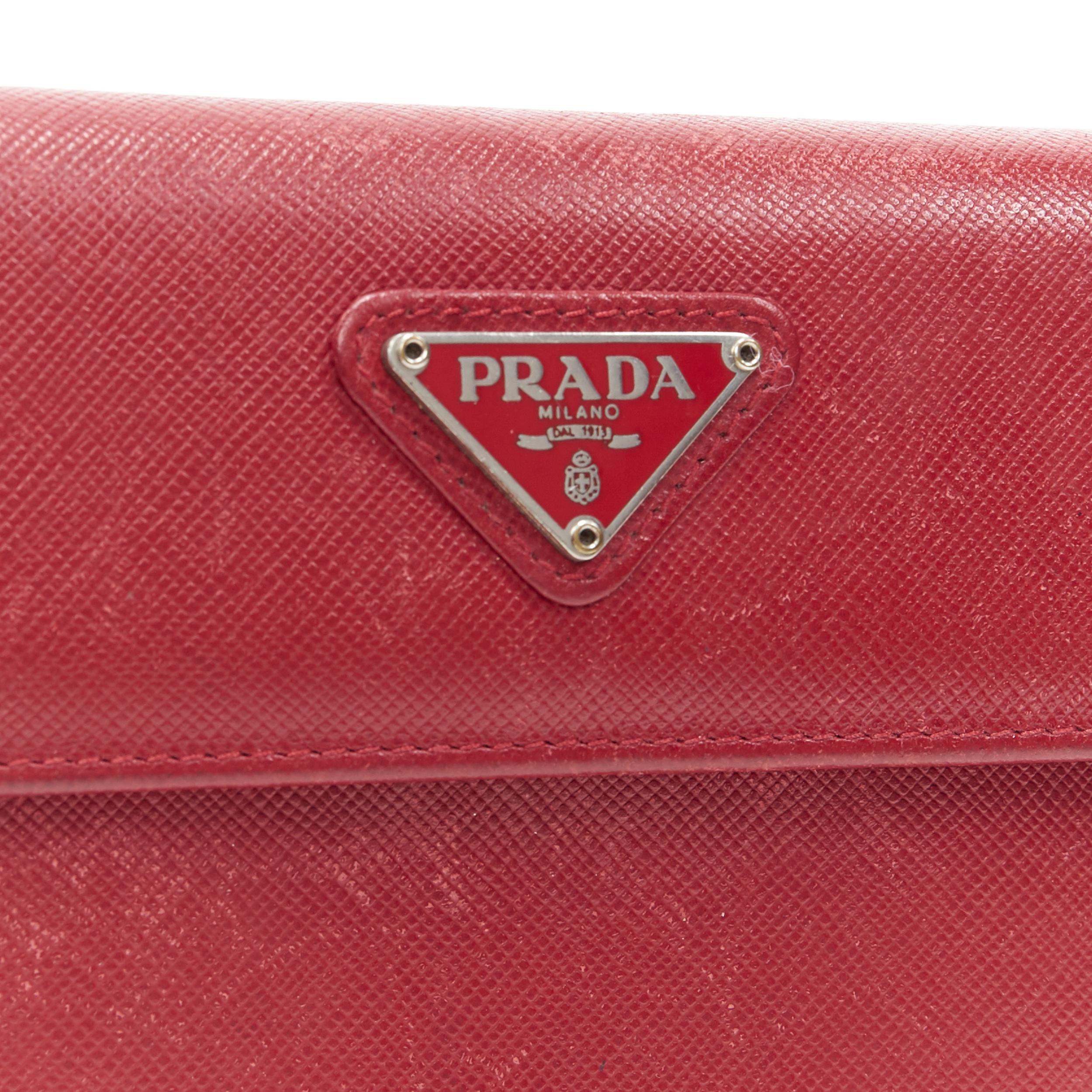 vintage PRADA red saffiano leather triangular plaque flap wallet
Brand: Prada
Model Name / Style: Leather wallet
Material: Leather
Color: Red
Pattern: Solid
Closure: Button
Made in: Italy

CONDITION: 
Condition: Poor, this item was pre-owned and is