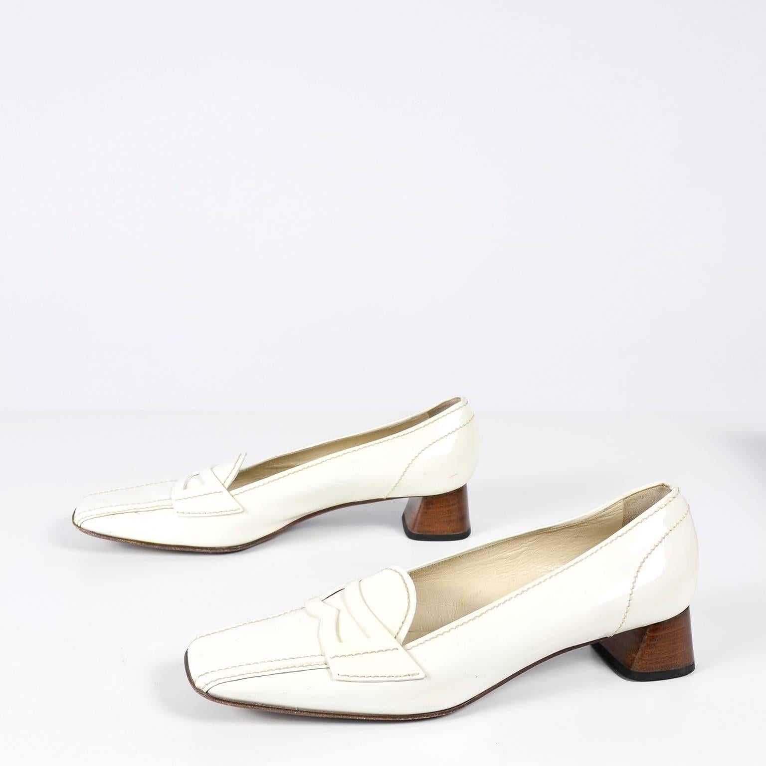 These vintage Prada shoes are in ivory patent leather have great squared toes and wood block heels.  They were made in Italy and are a heeled loafer style.  The shoes are labeled a size 39.5 and measure 3 and 1/4