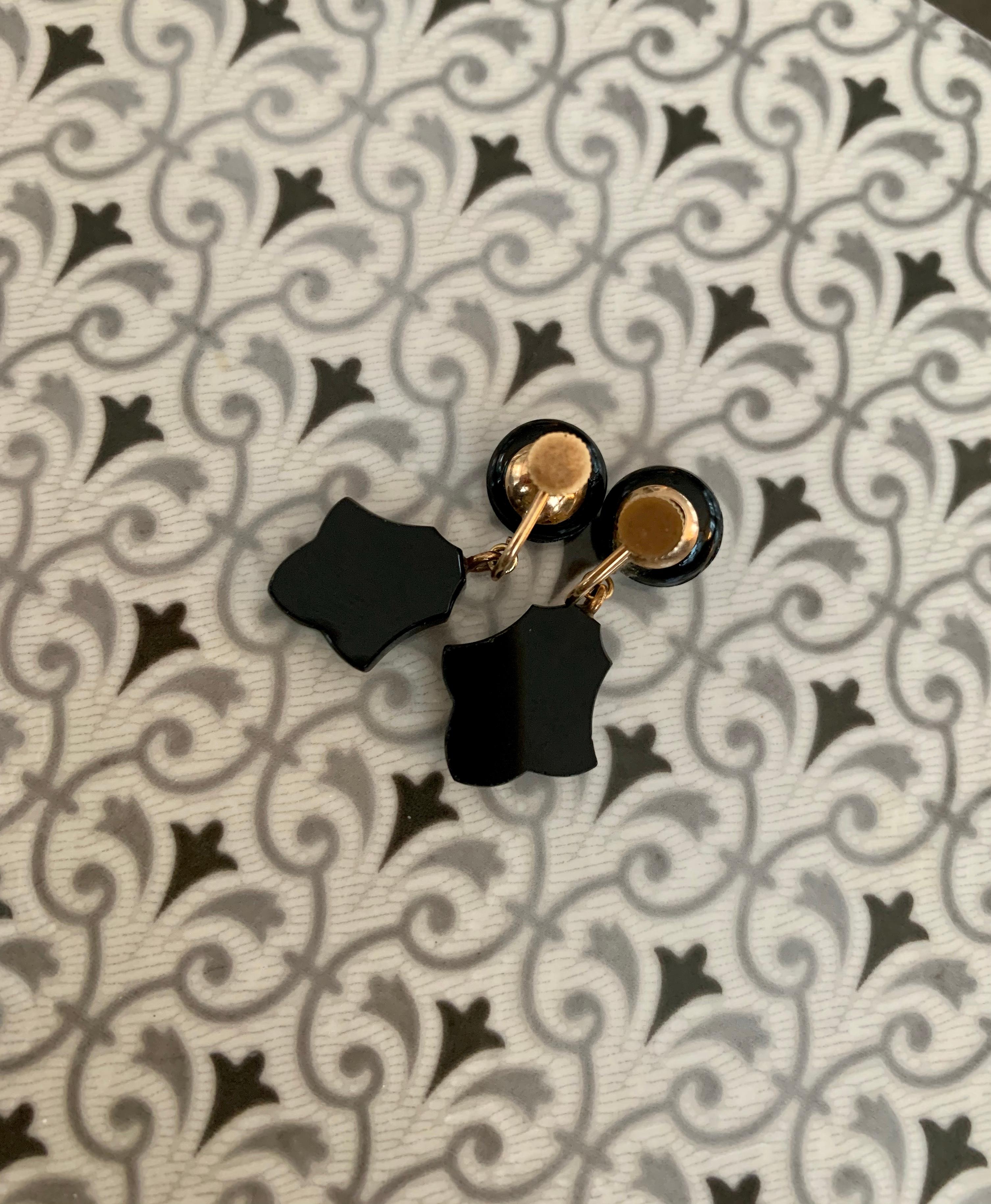 These vintage (pre-1930's) drop earrings feature beautiful pieces of black Onyx hanging from a round, faceted button of Onyx which sits on the wearer's earlobe.  The closure is a screw back, but could easily be converted to a post or wire for