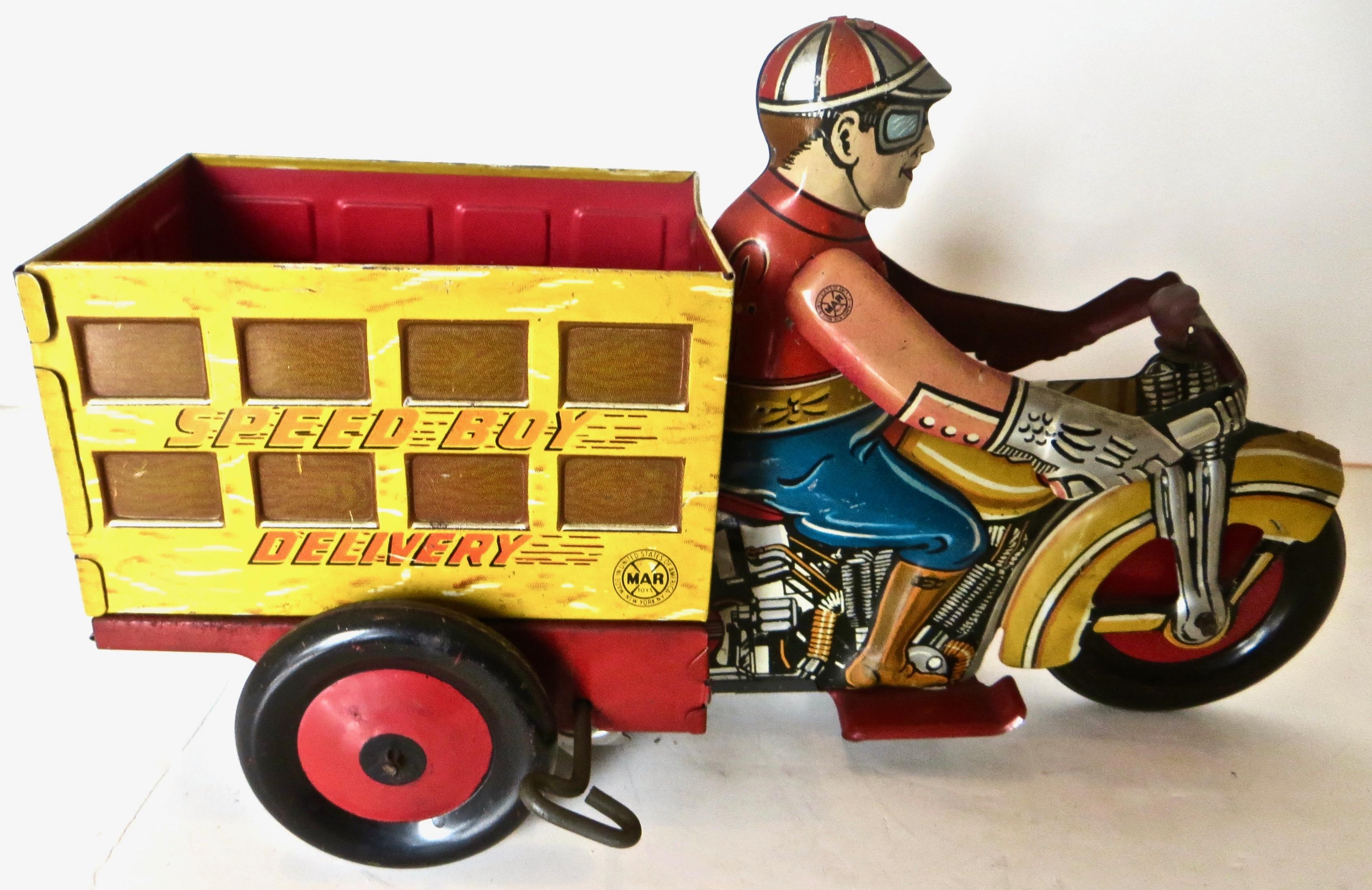 This brightly lithographed tin wind-up toy in colors of red, yellow, and blue, with a driver dressed in appropriate motorcycle clothing, depicts a young man driving a delivery cart with 