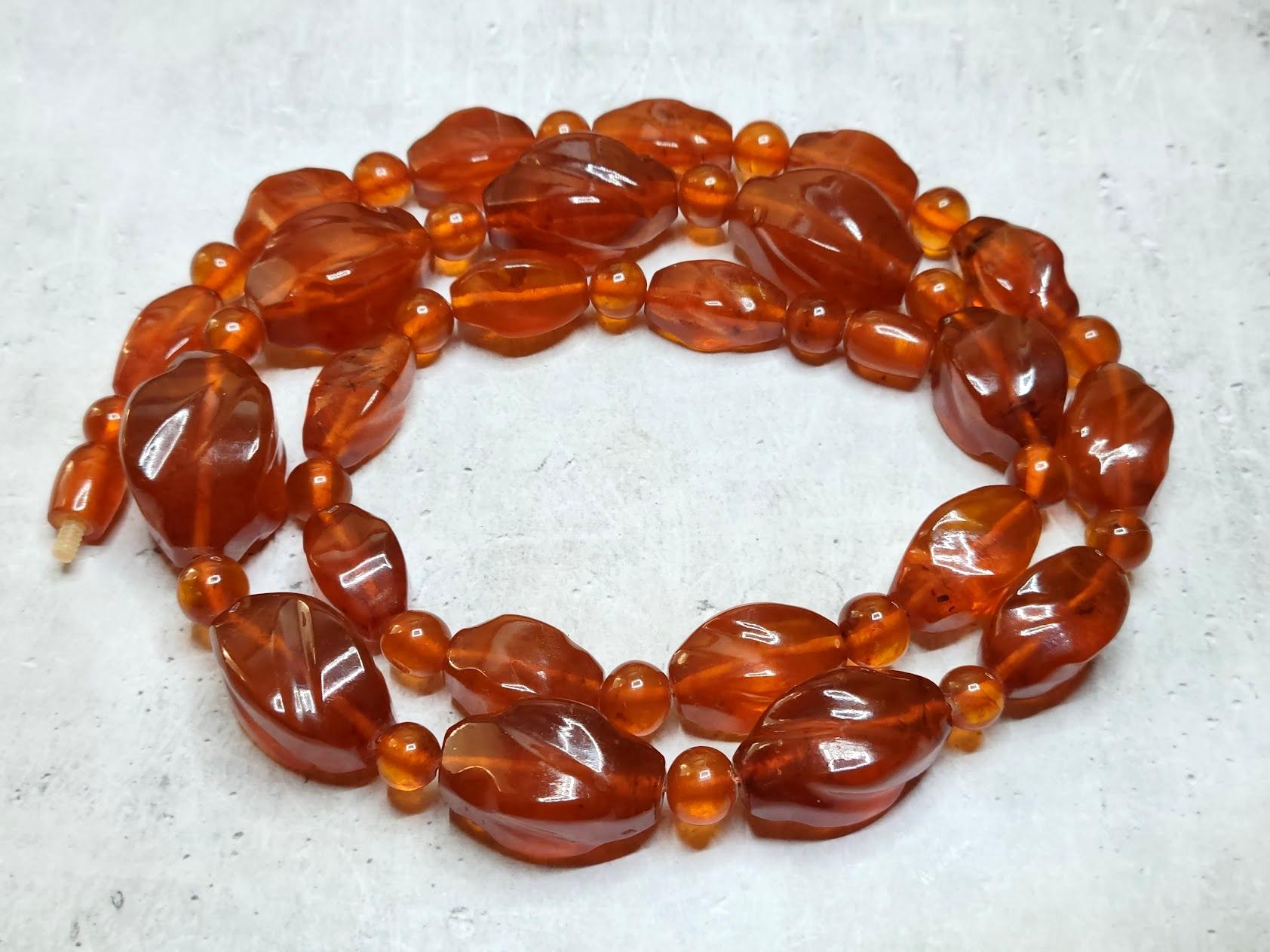 Vintage pressed cognac Baltic amber carved graduated beaded necklace with 4-sided swirl oval beads alternating with smaller round spherical beads ending with a hidden bead barrel twist closure. Such a high-quality amber press has a precious feature