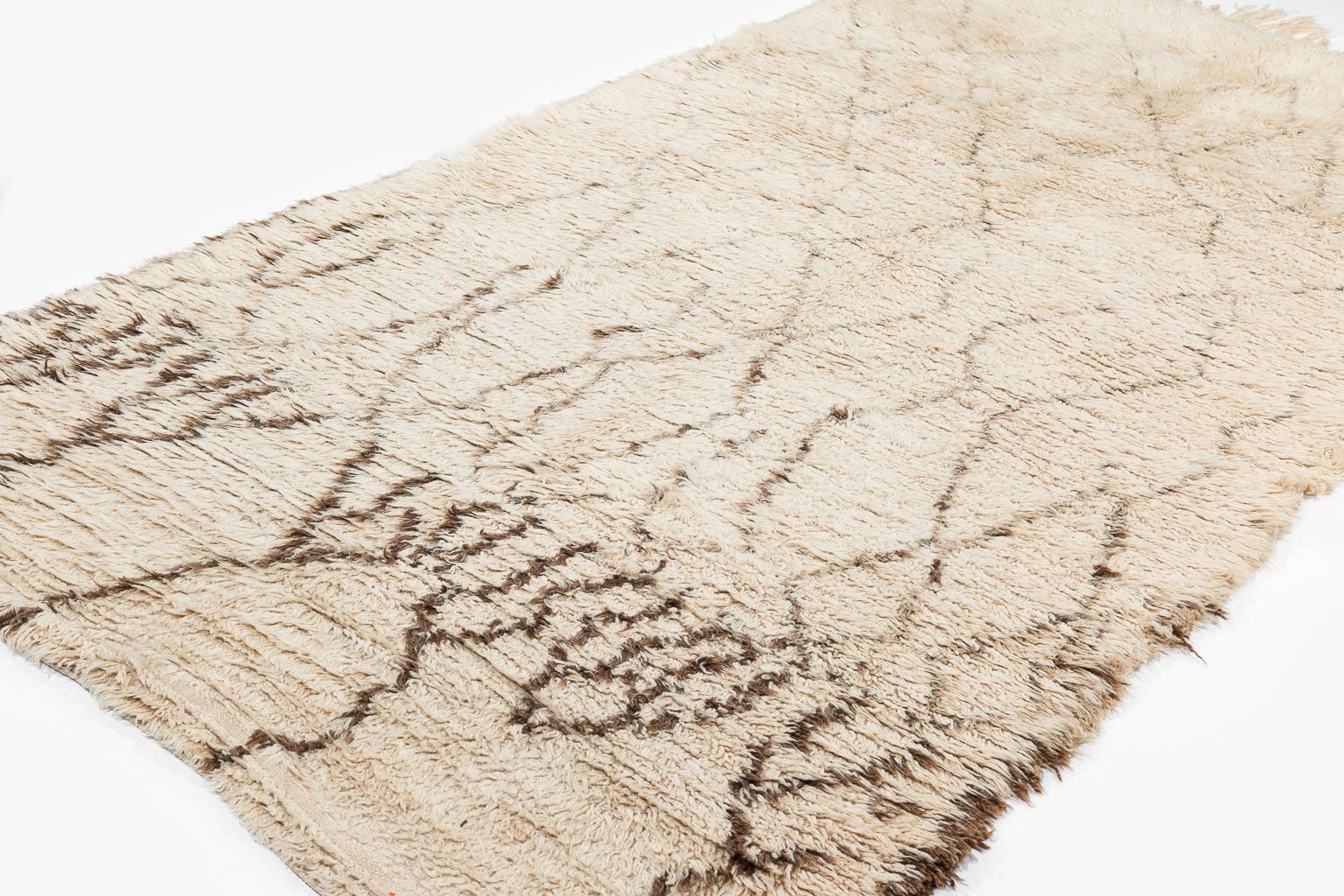 This Beni Ouarain Berber rug is in the top range of what one can find today in authentic vintage Beni white rugs. Calm overall but with an impressive drawing on the beginning side that makes quite a statement. The texture of the wool has that silky
