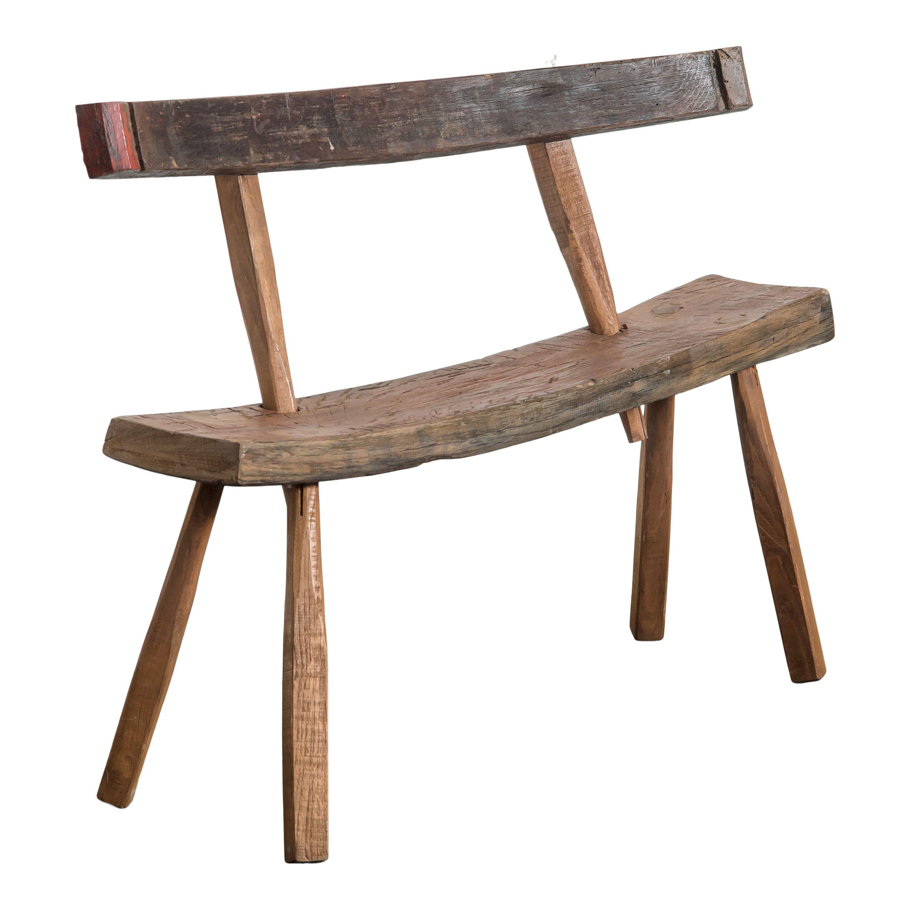 Panche antiche in legno di Oak provenienti dalla Francia. Le panche hanno uno stile rustico, con una seduta e uno schienale asimmetrici che creano una silhouette molto interessante.  La seduta e lo schienale sono entrambi semplici lastre di legno