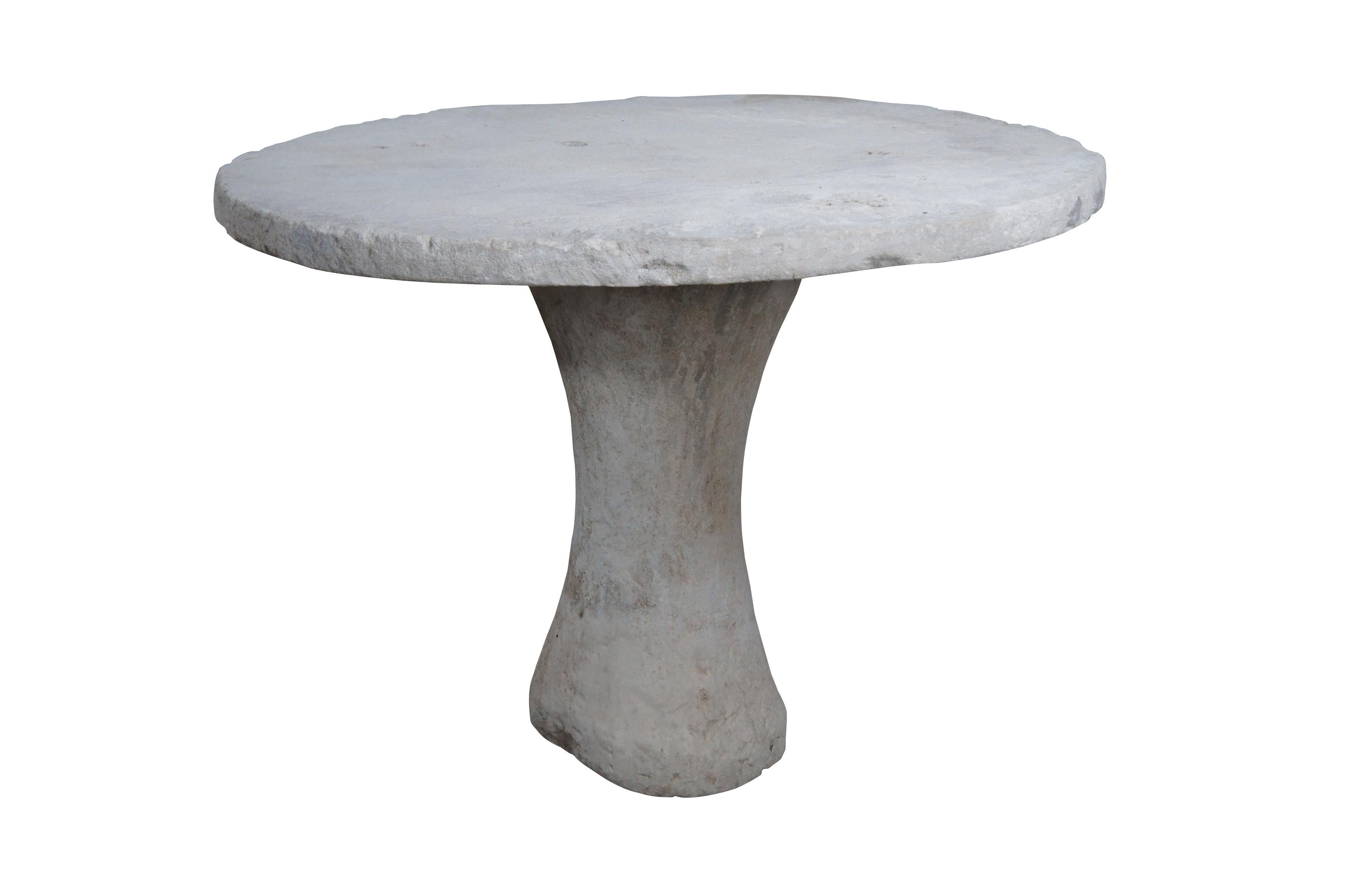 Vintage primitive style stone table featuring a pedestal base and round top. Very heavy, two pieces.