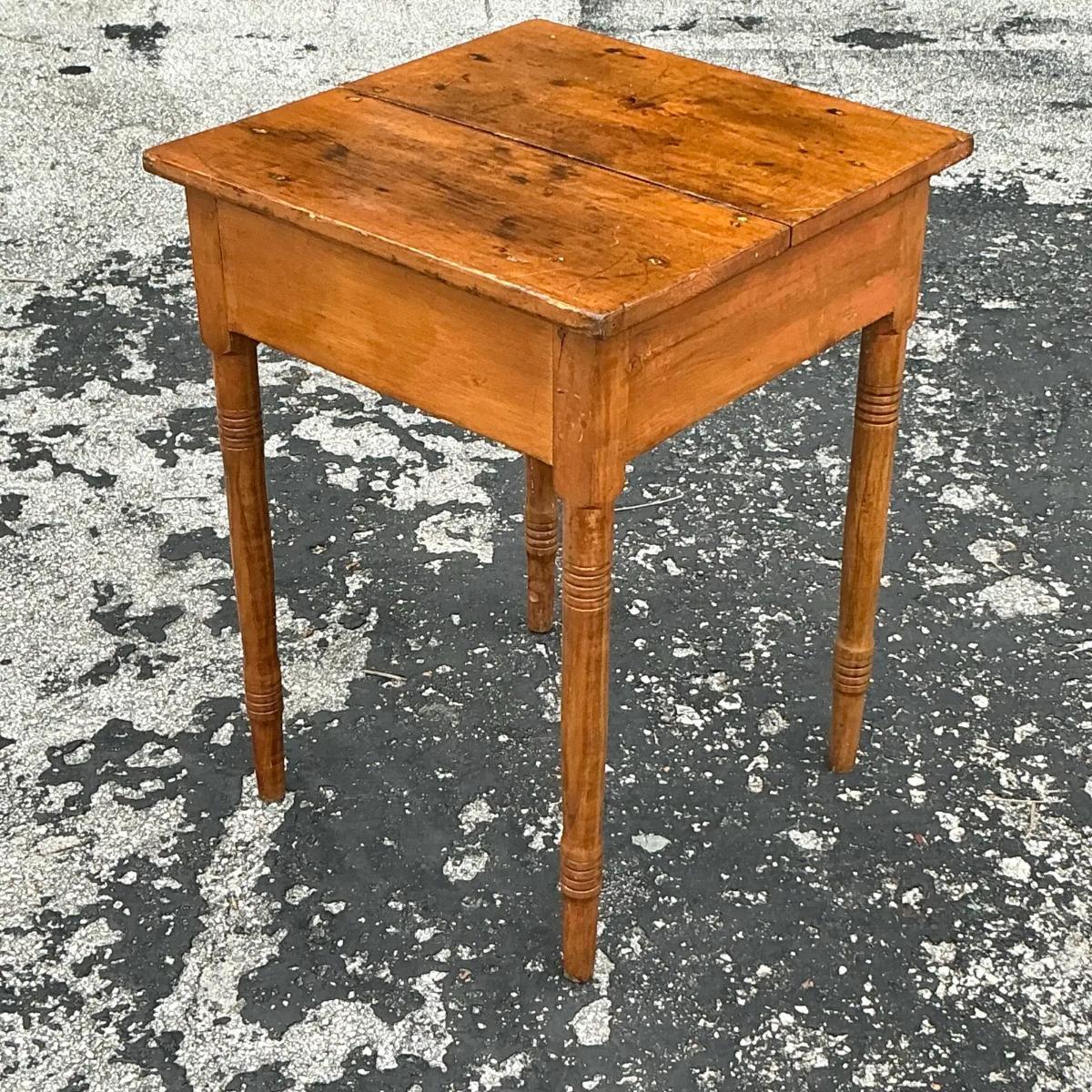 This vintage primitive side table showcases a simple, rustic design with a worn, handcrafted appeal. Its sturdy build and raw finish make it a perfect accent piece, adding warmth and character to any space.