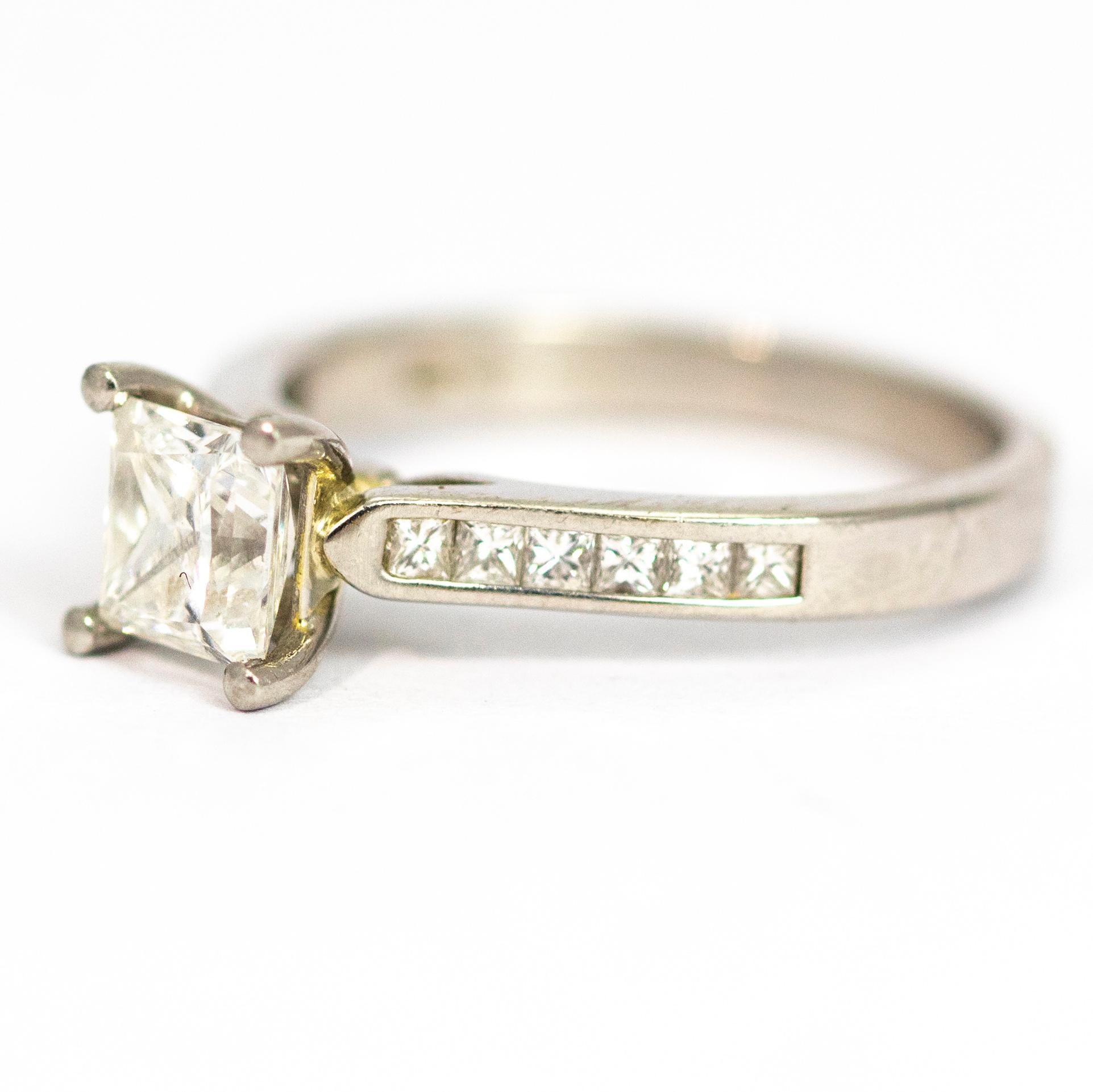 Questo anello è perfetto per il fidanzamento o per aggiungere un po' di brillantezza al tuo abbigliamento quotidiano. Il diamante centrale è un taglio princess che brilla meravigliosamente, mentre le spalle ospitano ciascuna una fila di sei diamanti
