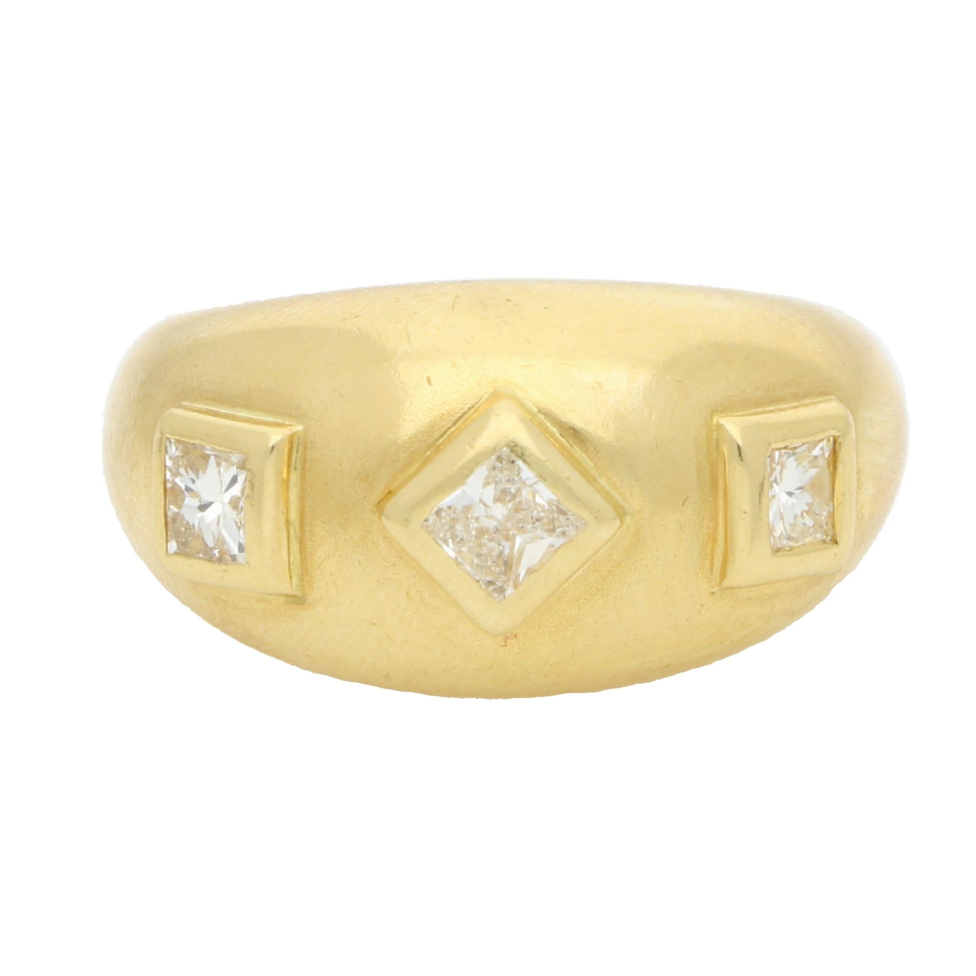 A stylish vintage princess cut diamond gypsy set domed ring set in 18k yellow gold.

The ring is comprised of three princess cut diamonds, set in a classic rub over gypsy style setting. The princess cuts are set in this raised domed chunky gold