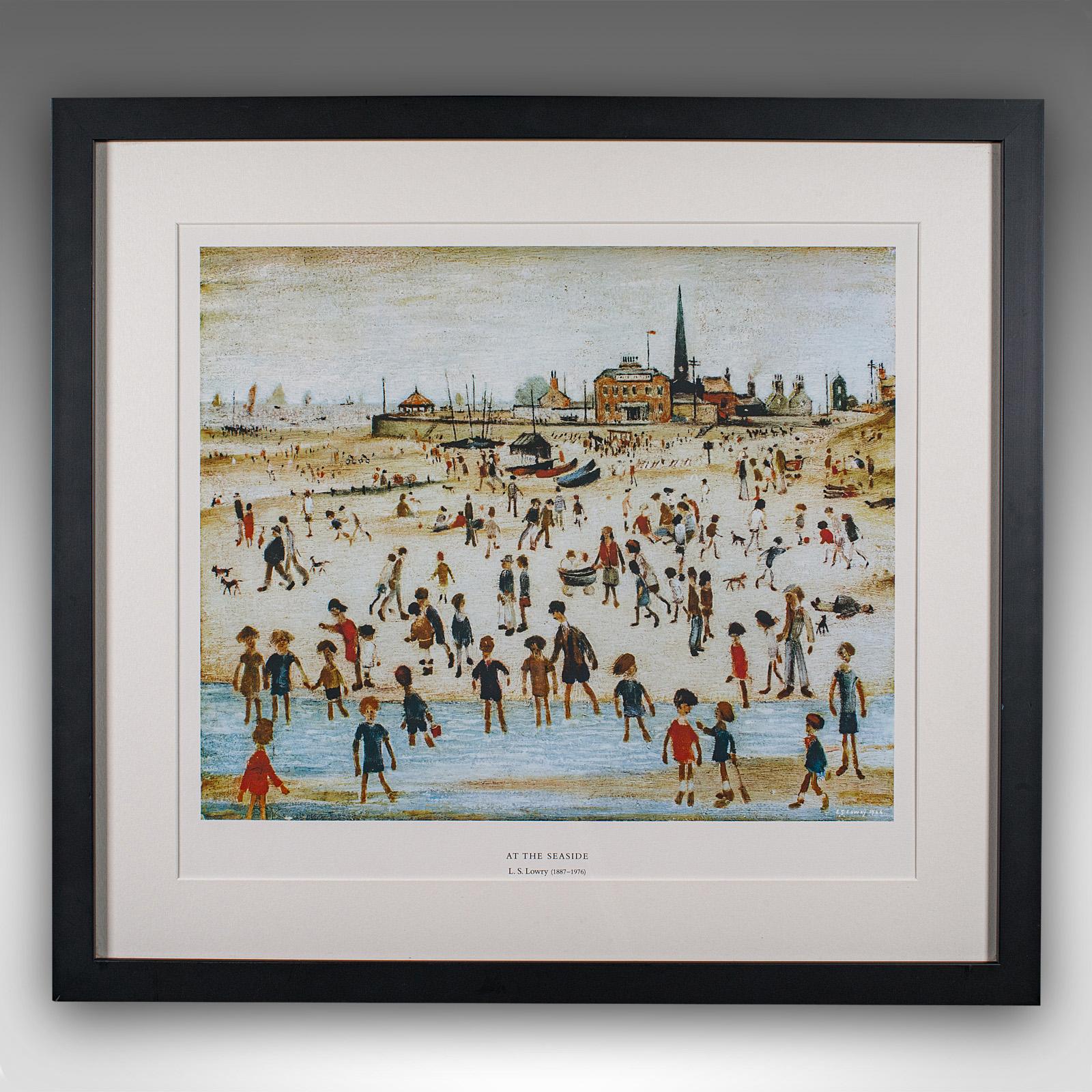 
This is a vintage print of At the Seaside by L.S. Lowry. An English, framed art reproduction of the fabled painter's coastal piece, dating to the late 20th century, after the original of 1946.

Laurence Stephen Lowry (1887 - 1976), commonly known