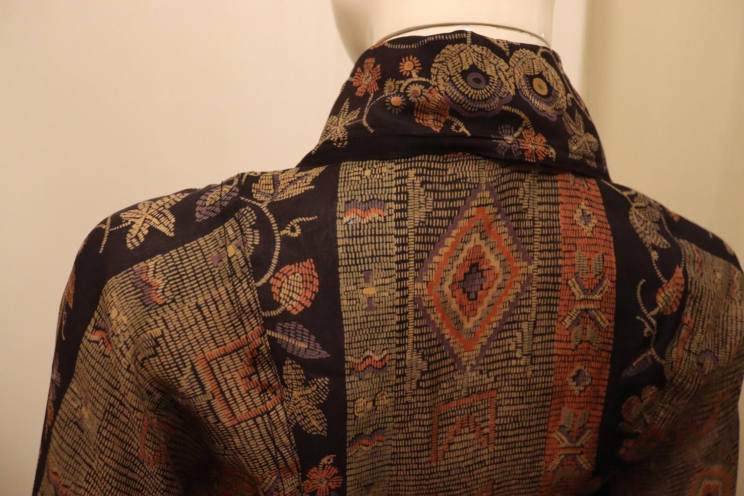 A headturning vintage dress by Jean Varon. 
The dress is in a wonderful print , with a front button and zip ( from waist ) opening. It has sewn in  pleats from the waist producing a sleak line and has a pocket on either side. It is unlined.