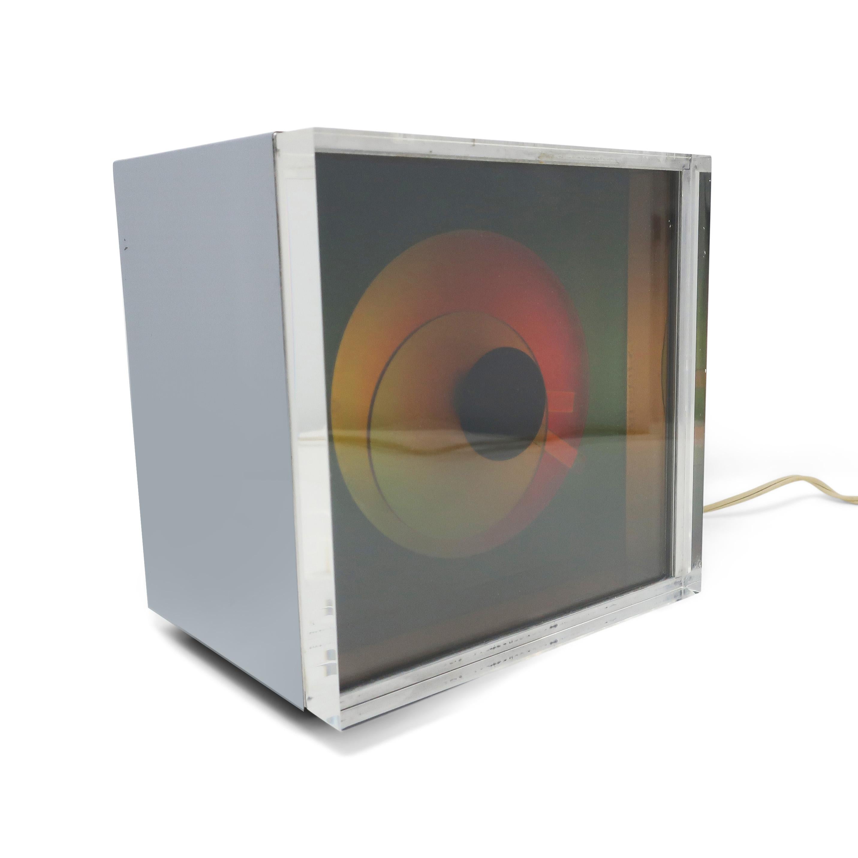 An op art inspired piece from 1976, the Prisma clock by Kirsch Hamilton Associates manages to capture vibrant colors, minimalism, and 1970s space age design. This mysterious color changing clock has a chrome body, thick lucite lens over laminated