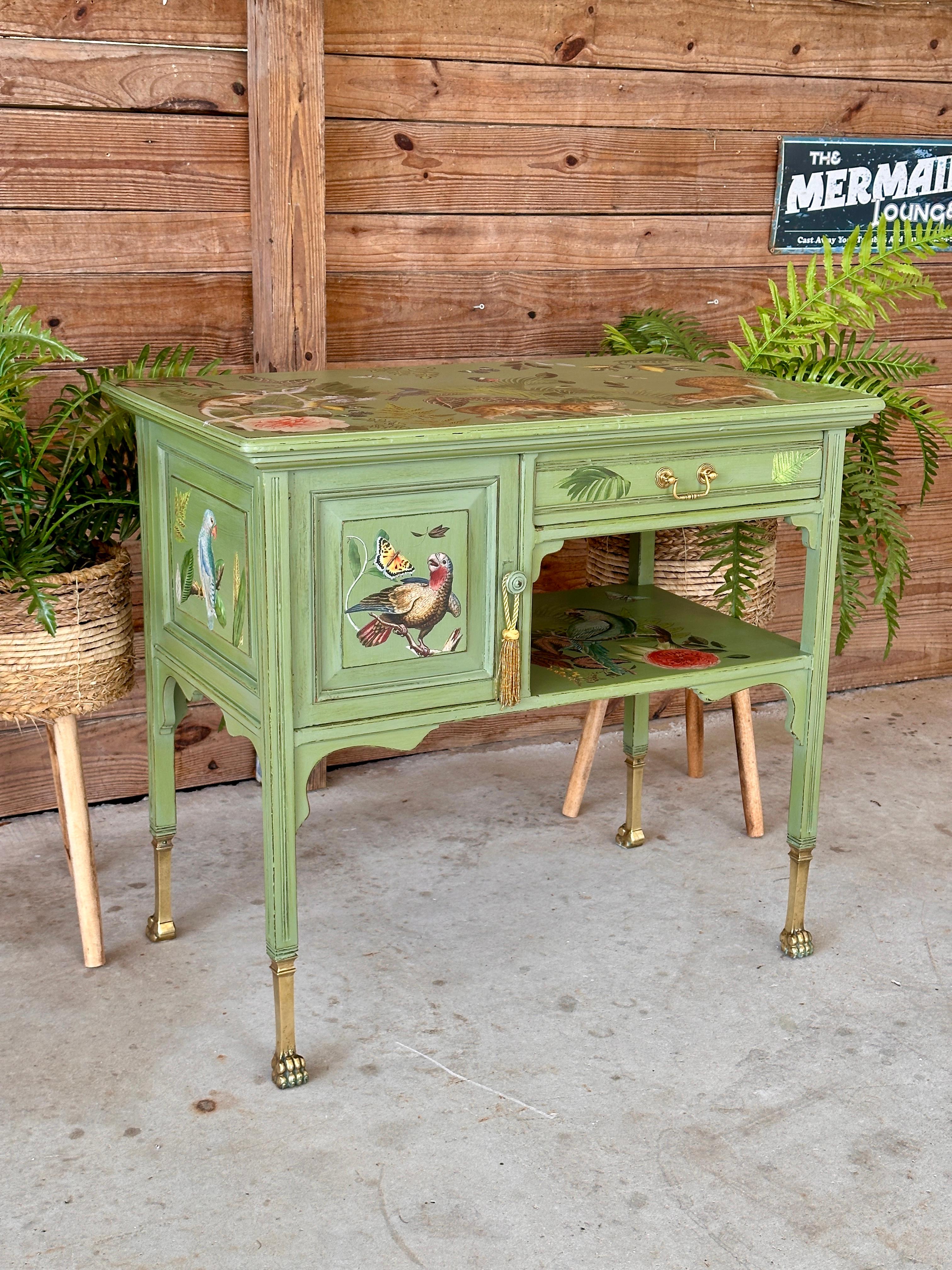 This unique vintage console or sideboard is a true work of art, showcasing a vibrant hand-painted and decoupage design that captures the beauty of nature.
The piece features lush botanical motifs, exotic birds, and playful animals, adding whimsical