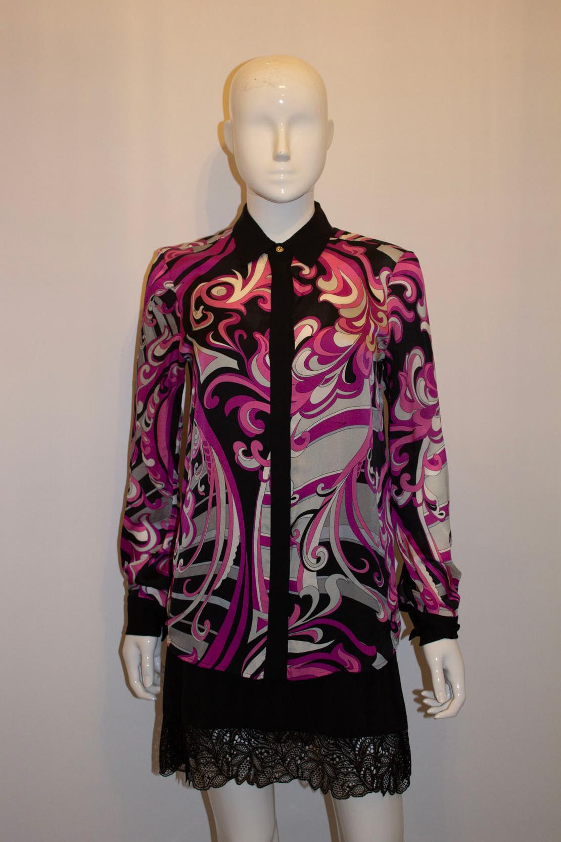  A pretty and chic vintage silk shirt by Italian designer Emilio Pucci. The shirt  is in a black, ivory , pink and magenta print. The shirt has long sleaves and single buttons cuffs. All the buttons are original Pucci. Size UK8 , Italian 40 .